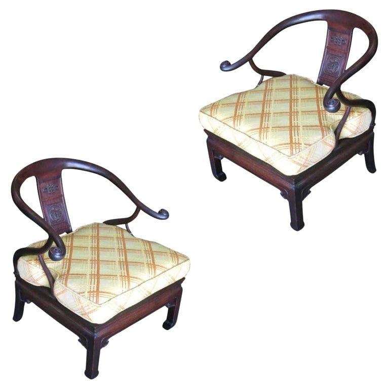 James Mont Style Horseshoe Lounge Chairs, Pair: Stunning pair of James Mont style Asian horseshoe armchairs.Both possess a dark stain wood frame with hand carved reliefs and decorations. The multicolored seat cushions feature a great original midce