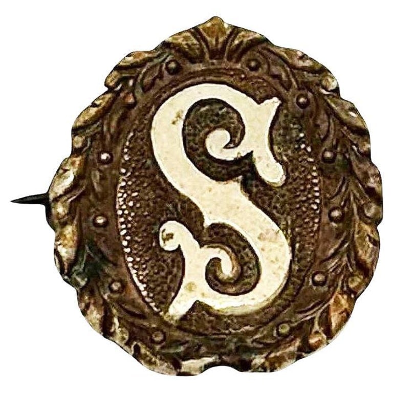 Victorian Gold Filled on Silver Intial "S" Laurel Wreath Border Pin Brooch: Turn-of-the-century oval initial "S" gold filled on the silver pin with a laurel wreath border featuring a pin-back design. Crafted with intricate detailing, it showcases delicate curves and flourishe
