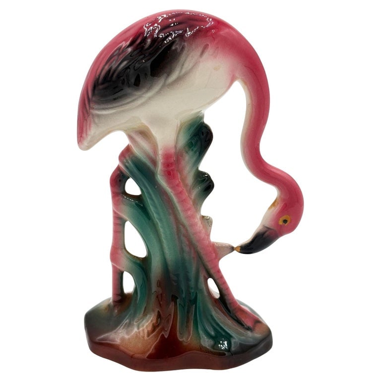 Atomic California Pottery Ceramic Grazing Tropical Pink Flamingo Figurine Statue: Mid-century pink and green flamingo ceramic figurine grazing on a grassy field . The statue depicts a pink flamingo with long legs, a slim, tall form kneeling down to graze on a grassy field. It comes