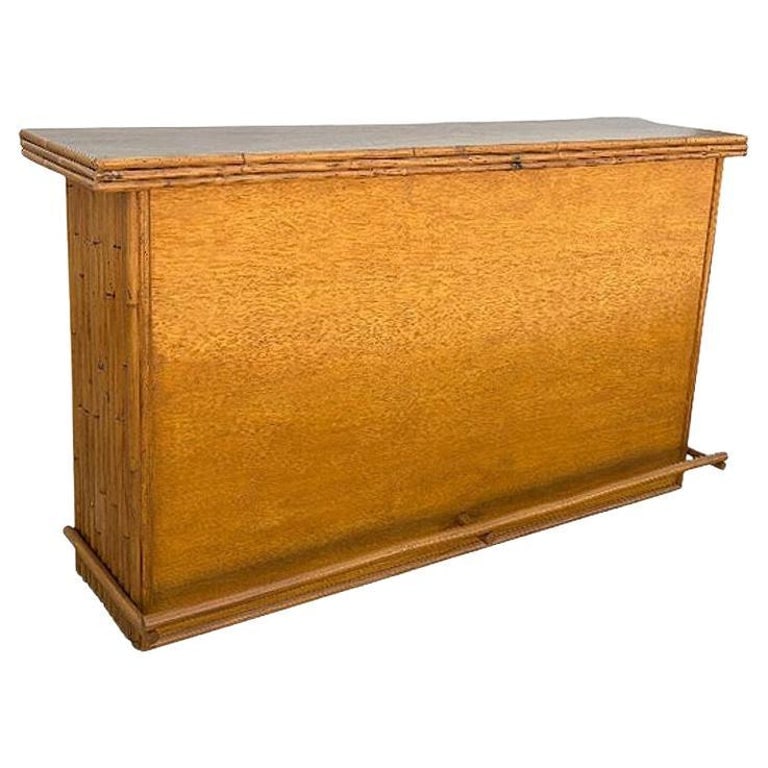 Restored Mid-century Rattan & Mahogany Bar w/ Foot Rest: This beautifully restored Paul Frankl-inspired large 42" wide Mahogany wood dry bar with vertically stacked rattan sides and a Mahogany top. The bar has two shelves along the back for easy storage of 