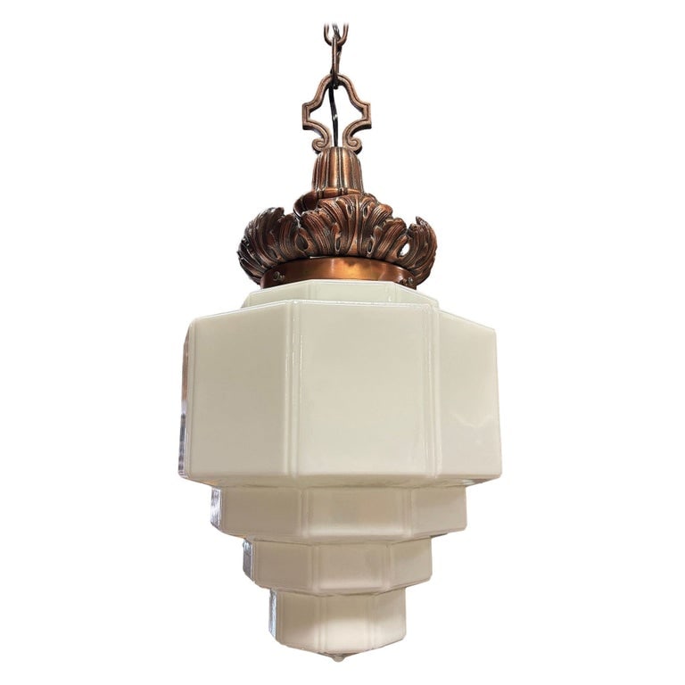 Art Deco Copper Acanthus Leaf Hanging Pendant Light w/ Stepped Milk Glass Shade: 1930s Art Deco pendant light featuring a stepped milk glass shade and ornate cast brass fitter with a warm copper finish. The crown showcases acanthus leaf detailing, adding a touch of neoclassical el