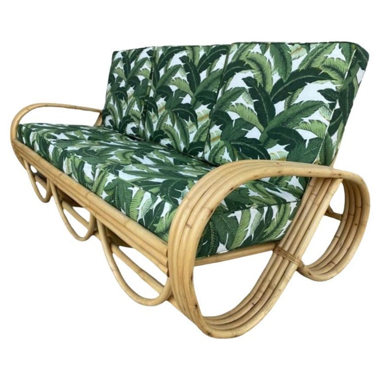 Restored Mid-century 4-Strand Rattan 3/4 Reverse Pretzel Sofa w/ Arched Base: This beautifully restored Paul Frankl-inspired Four-strand 3/4 reverse pretzel rattan sofa features a decorative scalloped detail on the base.Dimensions: 28" tall x 74" wide x 36" deepCirca: 1940s, Un