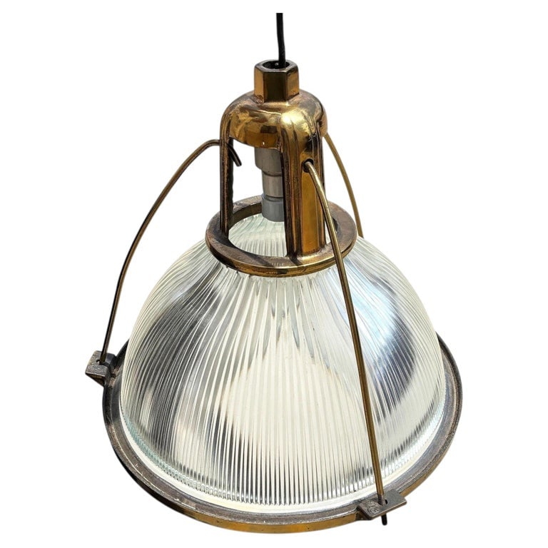 Rare Brass Plated Holophane Industrial Hanging Pendant Light: This industrial yet elegant hanging lamp from the 1940s features a Holophane glass shade. The pendant light is connected by an aluminum casing fixed to the top of the light fixture and is a rare brass