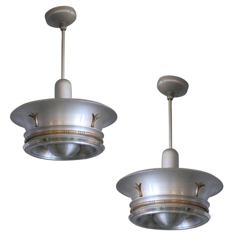 Aluminum Ceiling Pendant with Neoclassical Accents: Streamline Art Deco aluminum ceiling pendant pair, each model after the Transatlantic themes of aviation in the 1930s. Each comes with unique classical-based accents in brass, bringing a bit of class 