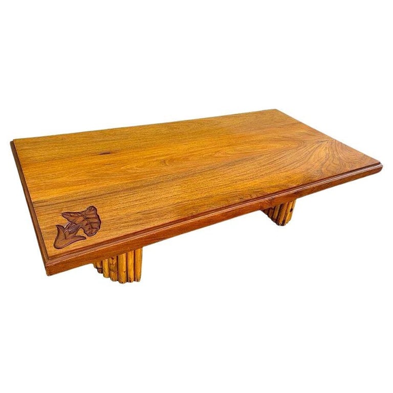 Mid-century Hand Carved Koa Wood Coffee Table w/ Stacked Rattan Legs: 1950's Koa Wood Coffee Table with Stacked Rattan Legs & Hand Carved Anthurium Motif along the corner. This stunning 1950s coffee table showcases the timeless beauty of koa wood, renowned for its rich