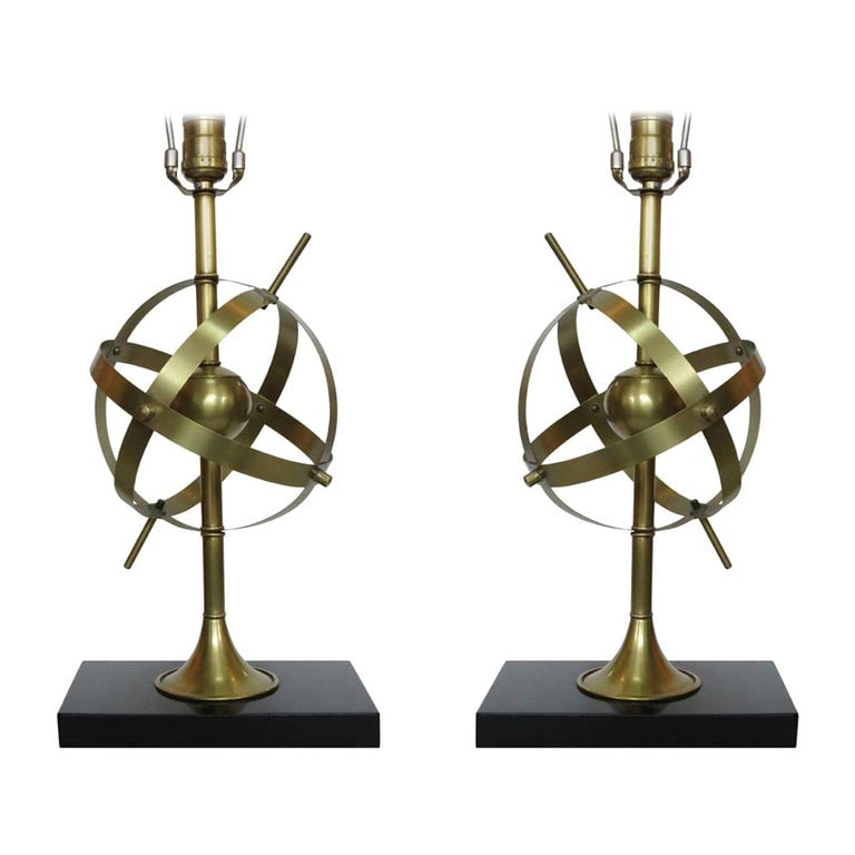 Brass Celestial Armillary Globe Study Table Lamp, Pair: Made circa 1950, each Mid-century solid brass study lamp features an armillary globe as the centerpiece and is fixed to a black lacquered wood base.