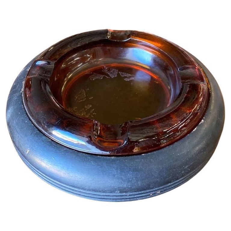 Round Dark Gold Amber 8" Glass Art Deco Ashtray w/ Ebony Holder: Large Art Deco era 7.5" round dark amber glass ashtray with four cigarette rests, rests in a black painted wood base.Circa 1930Can also be used as a coin or key dish.