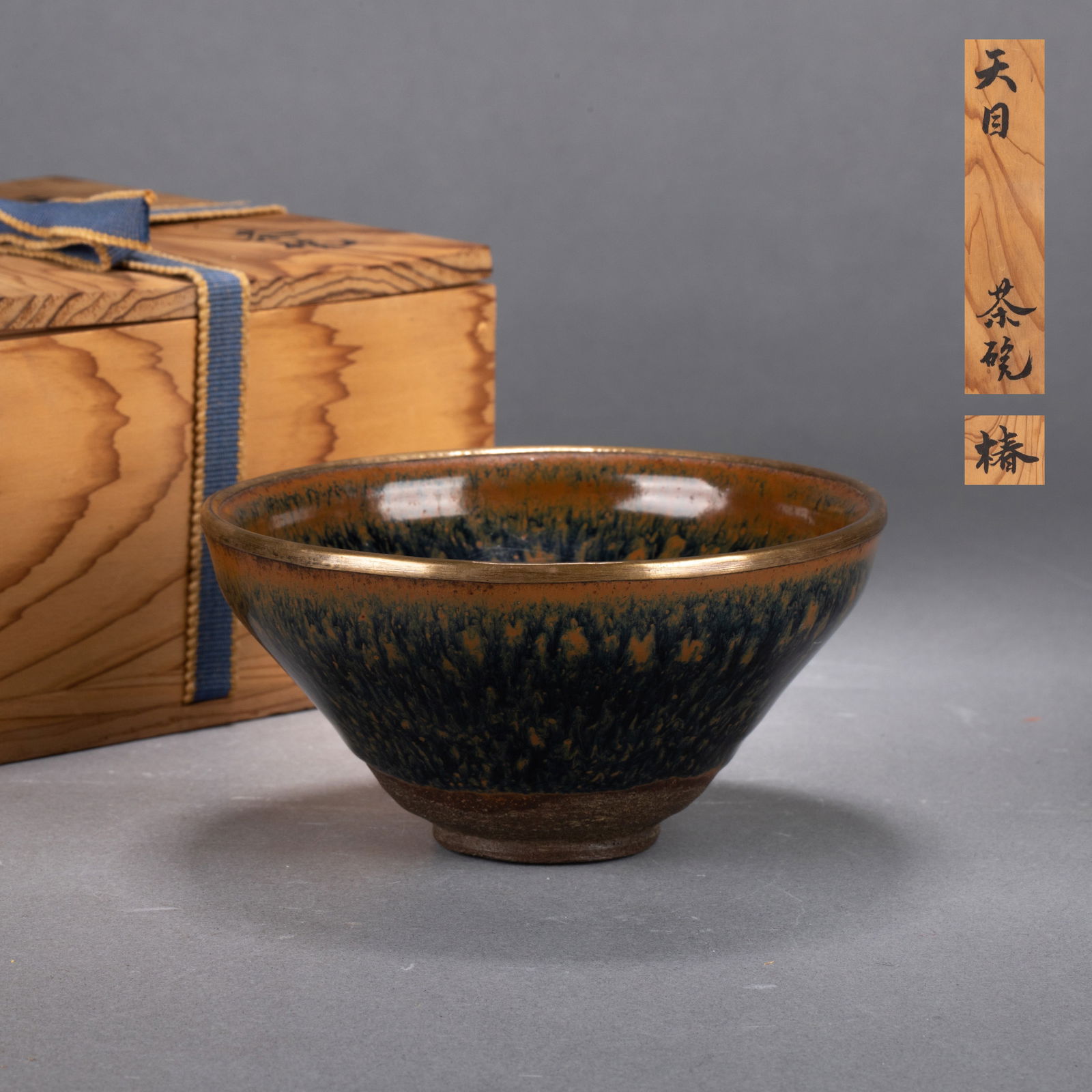 Song Dynasty Jian Ware ‘Oil-Drop’ tea cup with rolled rim: Song Dynasty Jian Ware ‘oil-drop’ tea cup with rolled rim – Dignified form with copper-mounted rim; deep black-brown glaze with golden oil-drop spots like stars; smooth surface, exposed coarse r