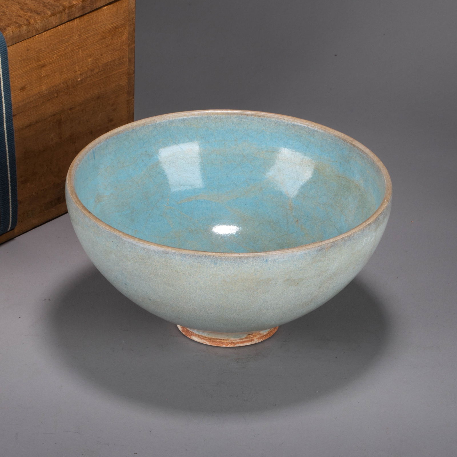 Jun ware bowl: Jun ware -This Jun ware bowl features an open mouth and a gently curved belly, characterized by a full, dignified form. The entire vessel is covered in a sky-blue glaze, its color reminiscent of a fre