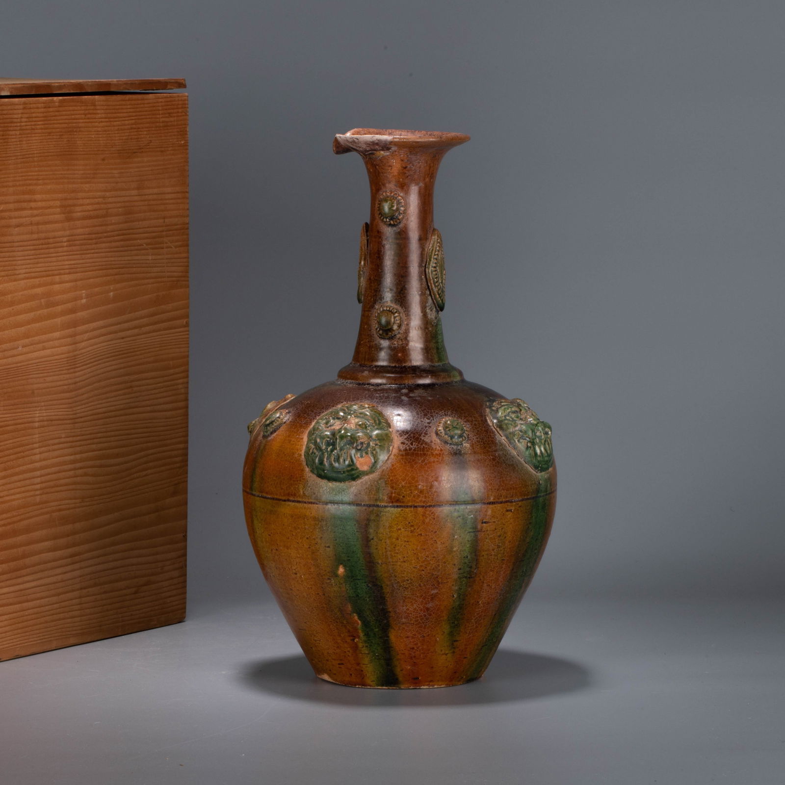Northern Dynasties tri-color (sancai) foreign-style flask: Northern Dynasties tri-color (sancai) foreign-style - This vase features a plump yet elegant form, with a slender, straight neck and a full, rounded body characterized by smooth, flowing lines. It is