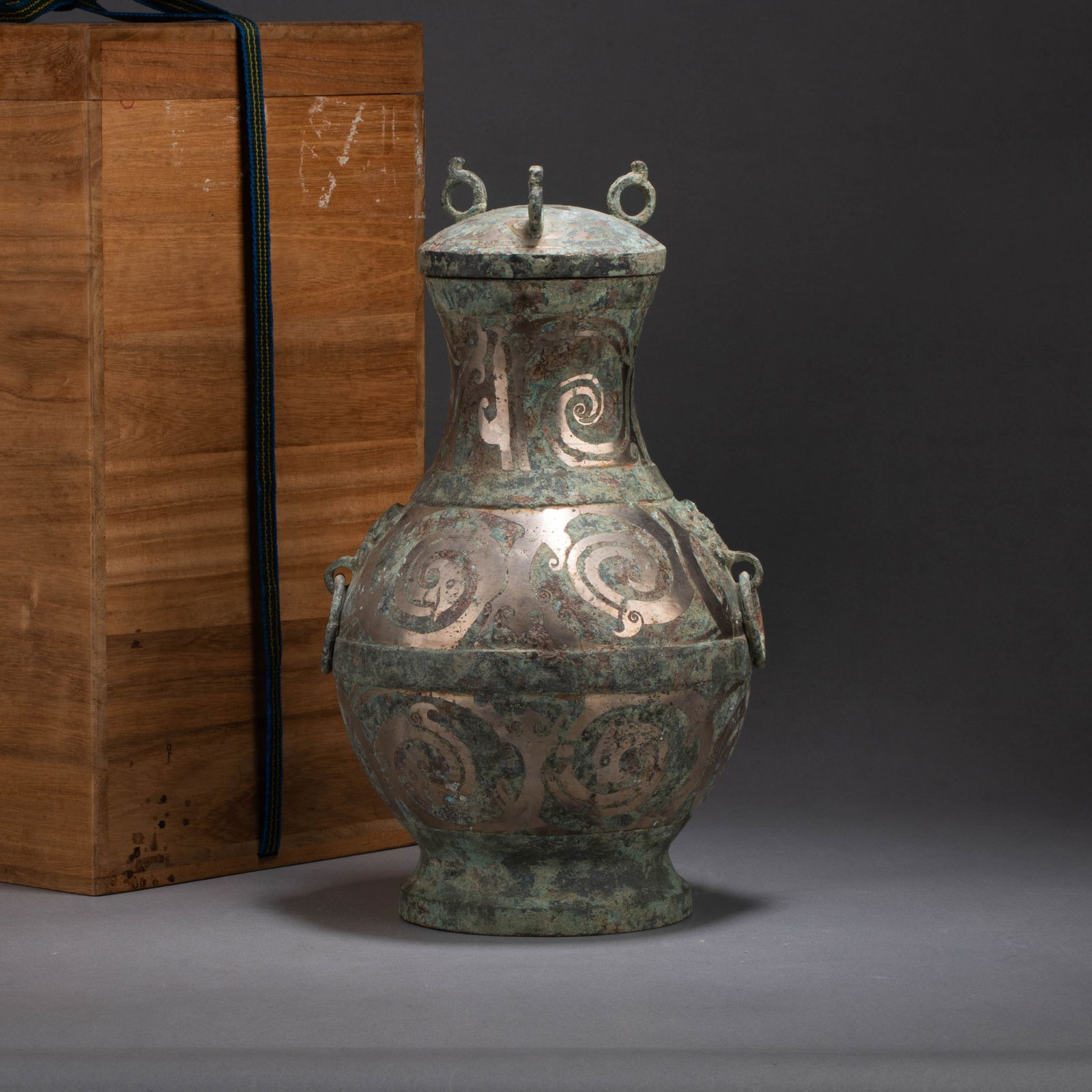 Warring States Period Silver-Inlaid Bronze Pot: Warring States Period Silver-Inlaid Bronze PotThis Warring States bronze vessel features a dignified form, with a constricted neck, a rounded belly, a high flaring ring foot, and a pair of loop handle