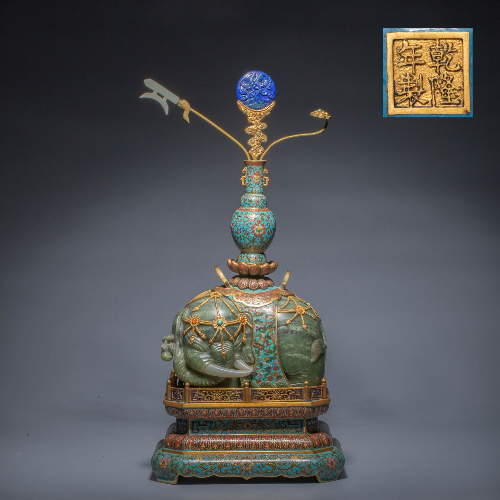 Qing Dynasty Cloisonné Enamel with Inlaid Hetian Jade "Auspicious Elephant Bringing Peace": Qing Dynasty Cloisonné Enamel with Inlaid Hetian Jade "Auspicious Elephant Bringing Peace"This decorative piece centers on a circular carving of an elephant in Hetian bluish-white jade, the jade warm