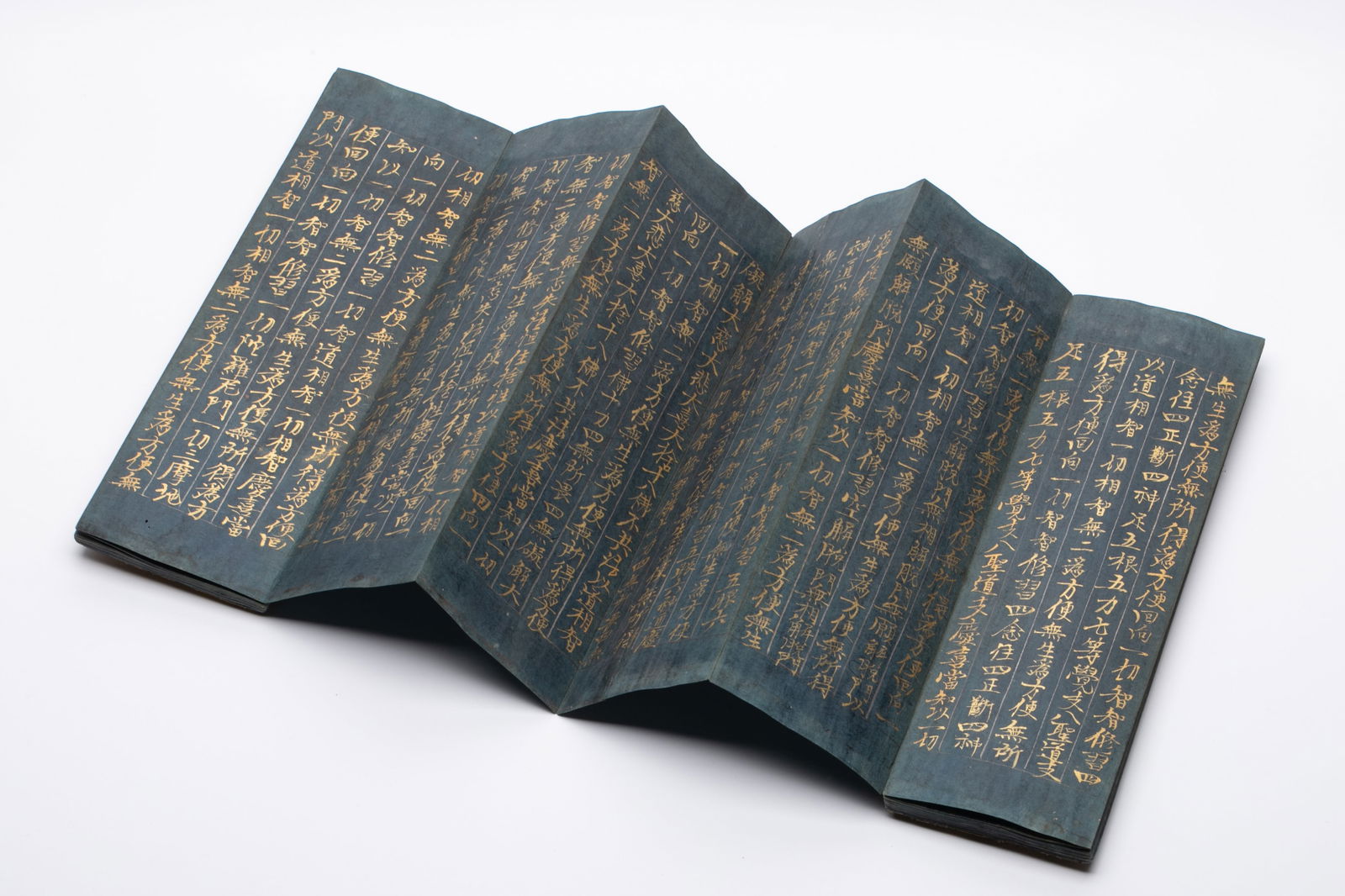 Mahaprajnaparamita Sutra Volume 111: Cyan Paper and Clay Gold: This sutra scroll is made of cyan paper and is written in clay and gold regular script. the paper is fine and the gold color is brilliant. the font is stable and dignified, the strokes are strong and