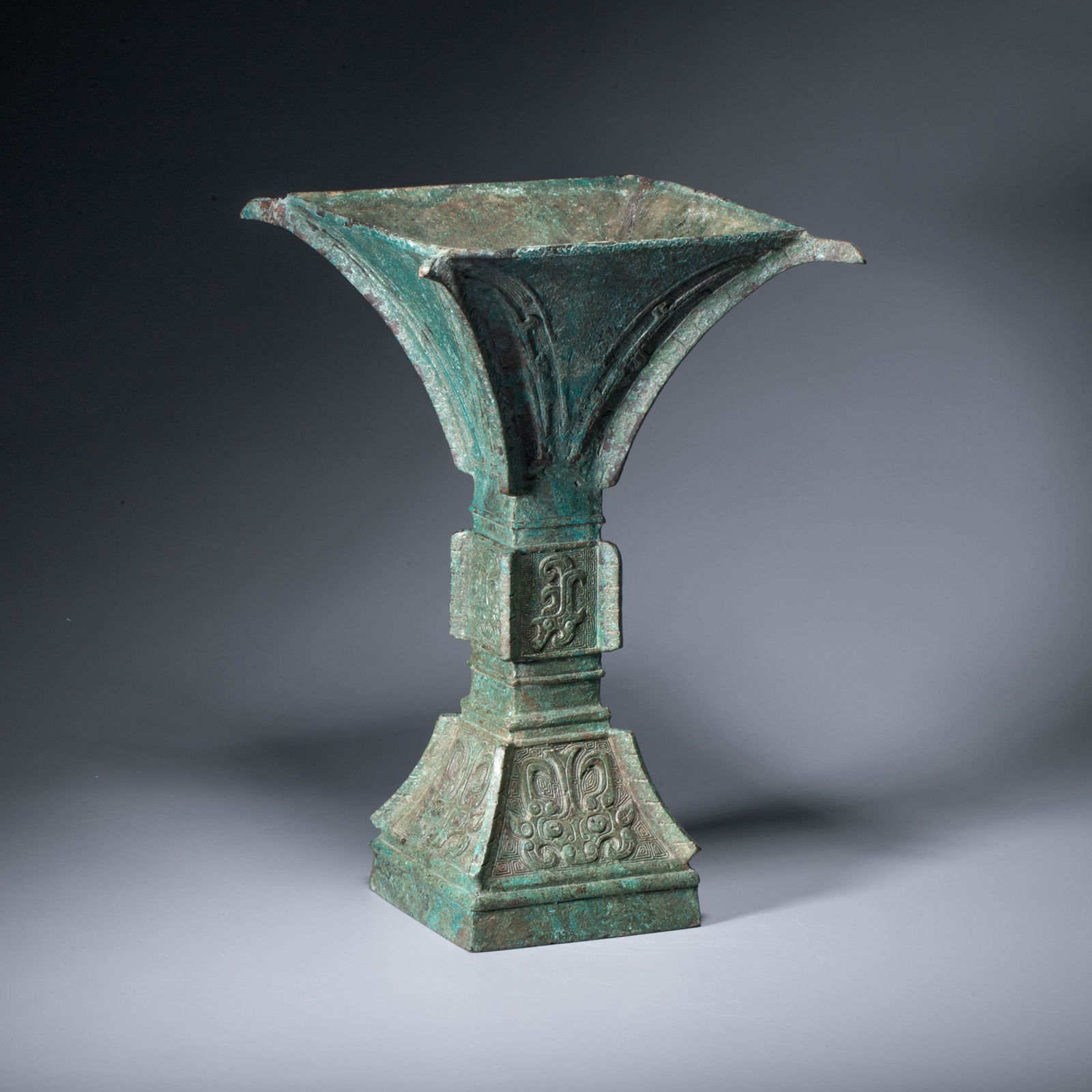 A bronze square-section gu decorated with taotie masks, Warring States period: A bronze square-section gu decorated with taotie masks, Warring States period