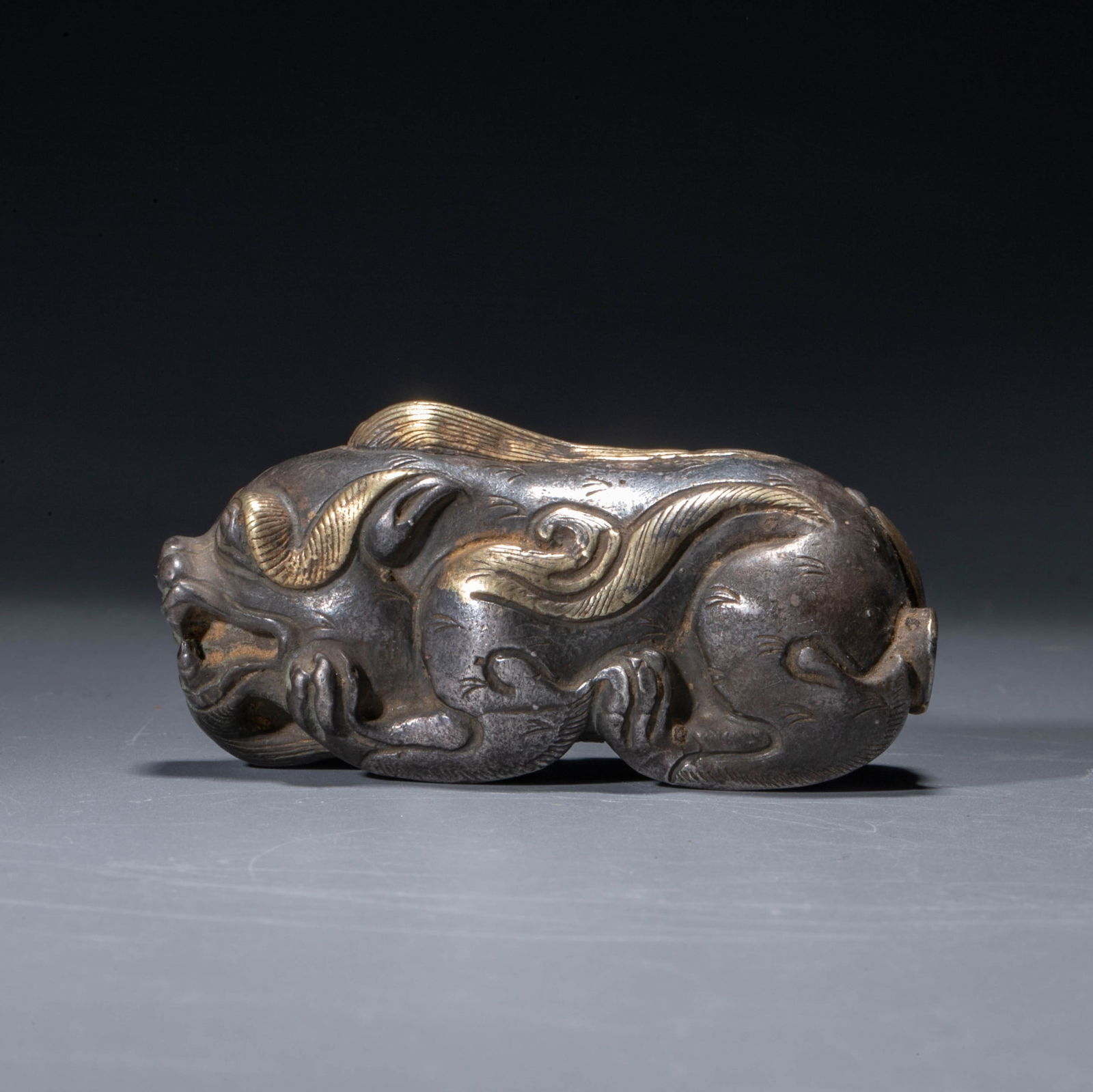 A silver-gilt lion-form paperweight, Han dynasty: A silver-gilt lion-form paperweight, Han dynasty
