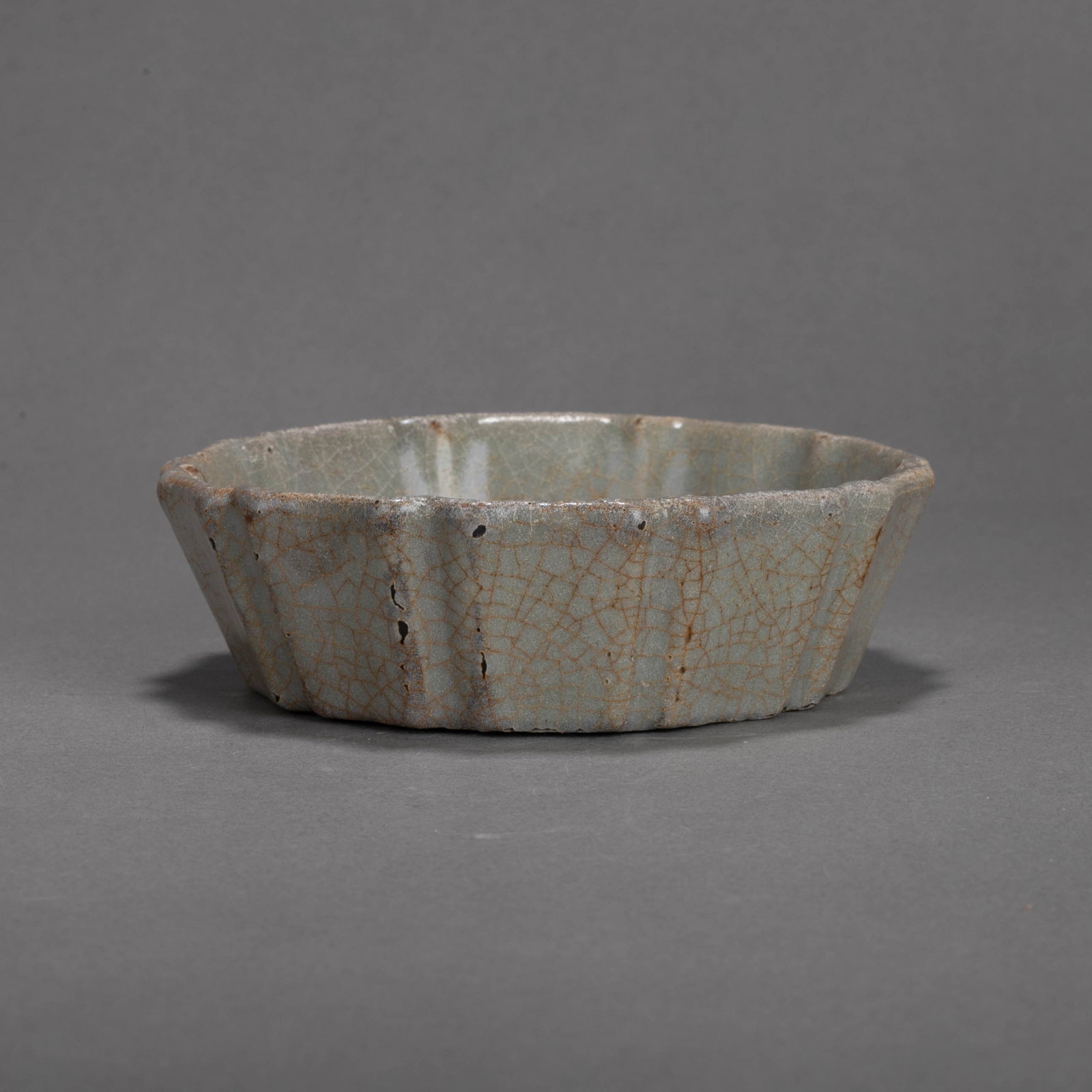 Southern Song Dynasty Guan warelobed rimbrush washer: This piece of lobed rimbrush washer has an open mouth with folded edges. The edges fluctuate with the ribs to form a petal-like outline. The outer wall is divided into multi-edges. The body has a