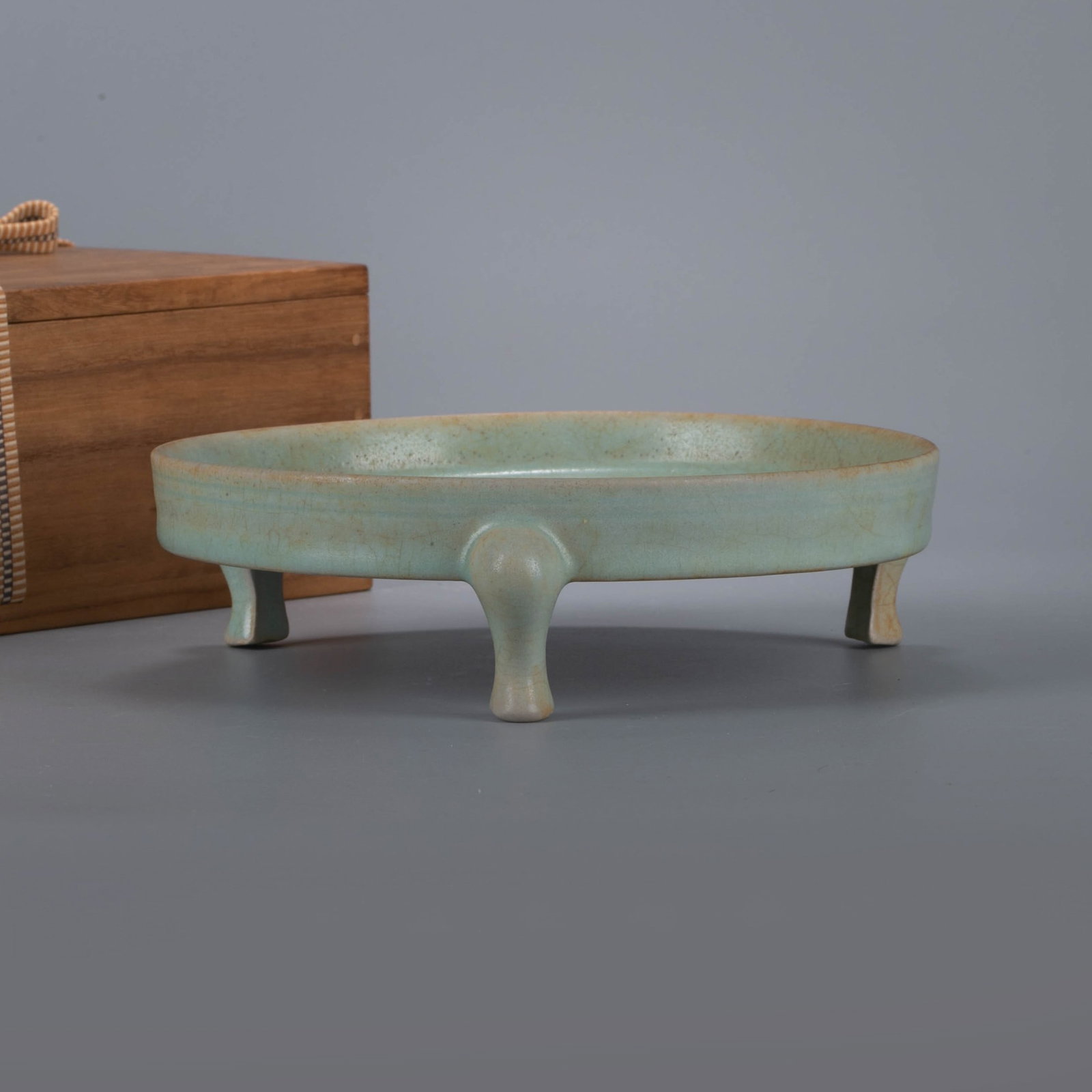 Ming Dynasty Longquan ware pink Celadon glaze open piece three-legged folded rim brush washer: The brush washer has an open mouth, slightly expanded fold edges, a shallow belly, and three legs underneath. The shape is dignified and elegant, and the proportions are coordinated. The whole body