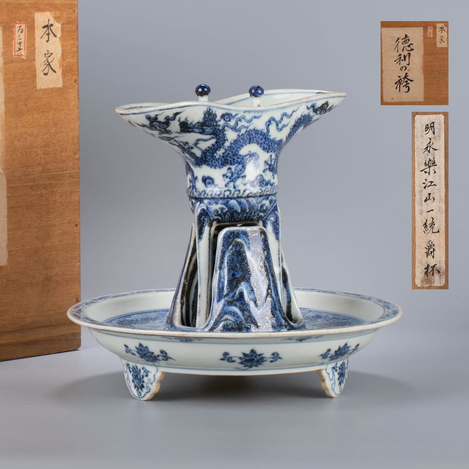 Ming Dynasty Yongle Jiangshan Yitong Jue Cup: This blue and white jue cup from the Yongle period of the Ming Dynasty is modeled after the ancient bronze wine vessel "jue". It consists of a cup body with a flow and a handle (handle) and a tray und