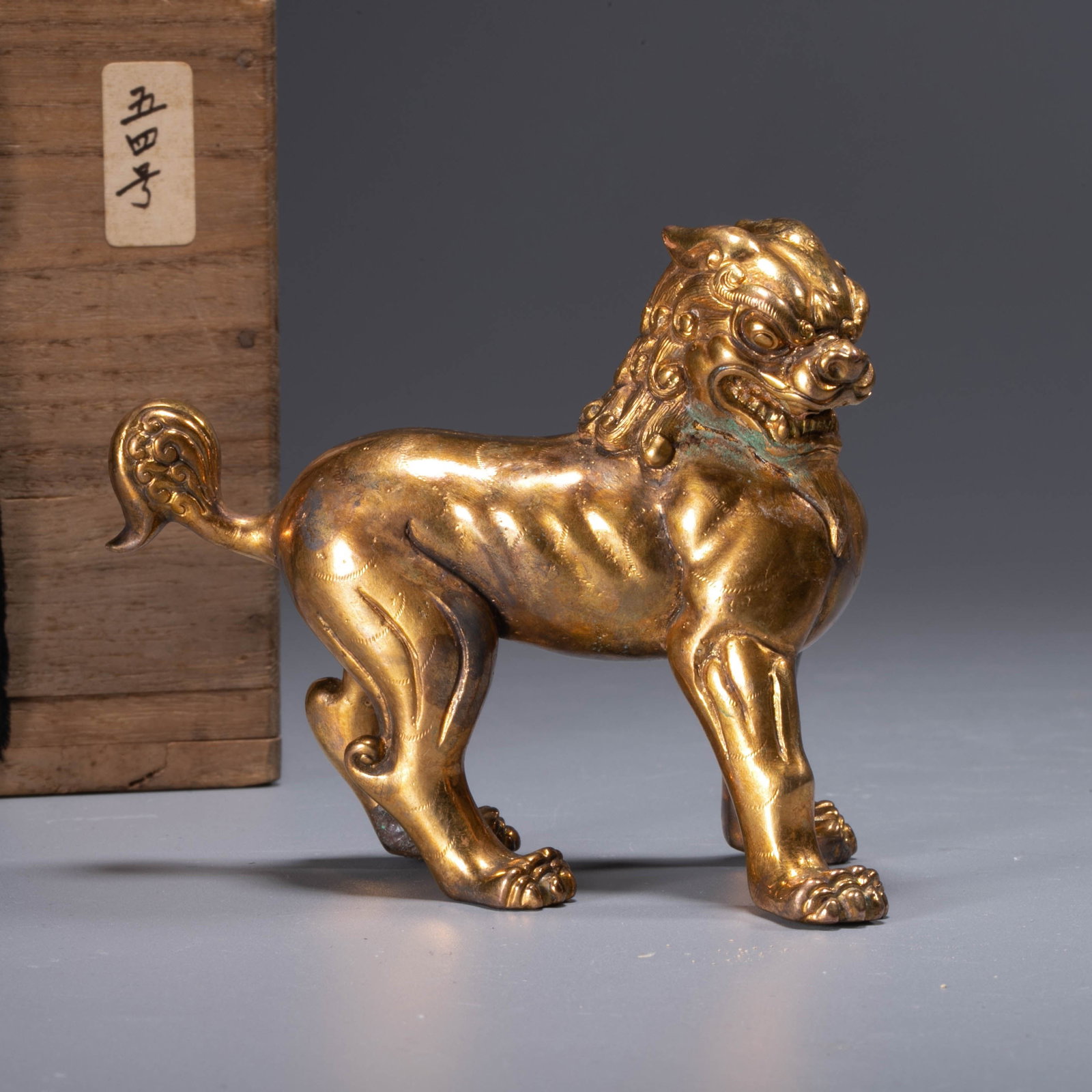 Tang Dynasty Gilt Bronze Lion: This gilt bronze lion from the Tang Dynasty has a strong and agile shape. It is in a standing posture, its limbs are firmly on the ground, its body is plump and round, and its muscle lines are exagger