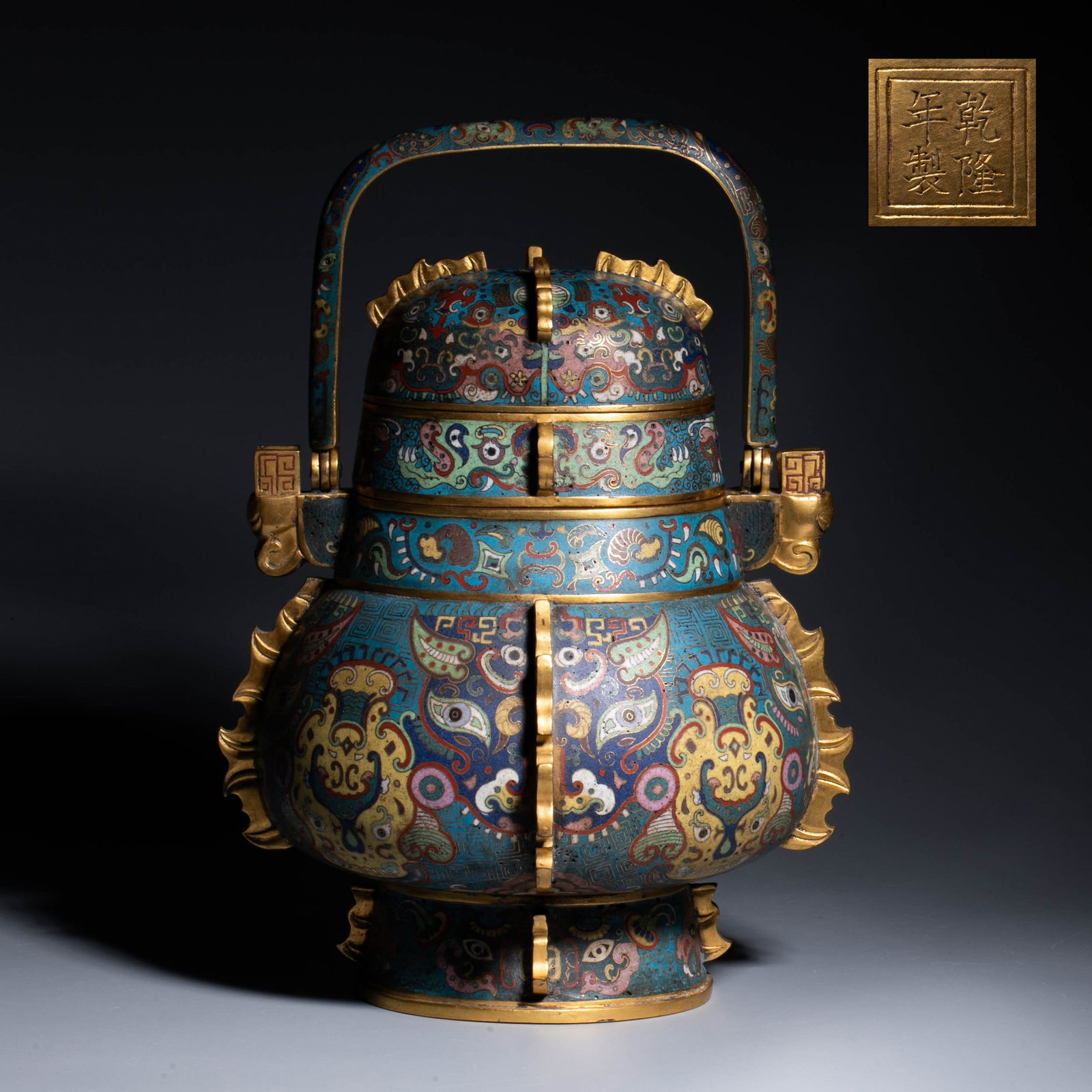 Qianlong Period, Qing Dynasty Cloisonn?? Enamel Handled Ewer: This cloisonn?? turban from the Qianlong period of the Qing Dynasty is shaped like a bronze ritual vessel from the Shang and Zhou dynasties. It is in the shape of an ellipse, with a cover, a button on