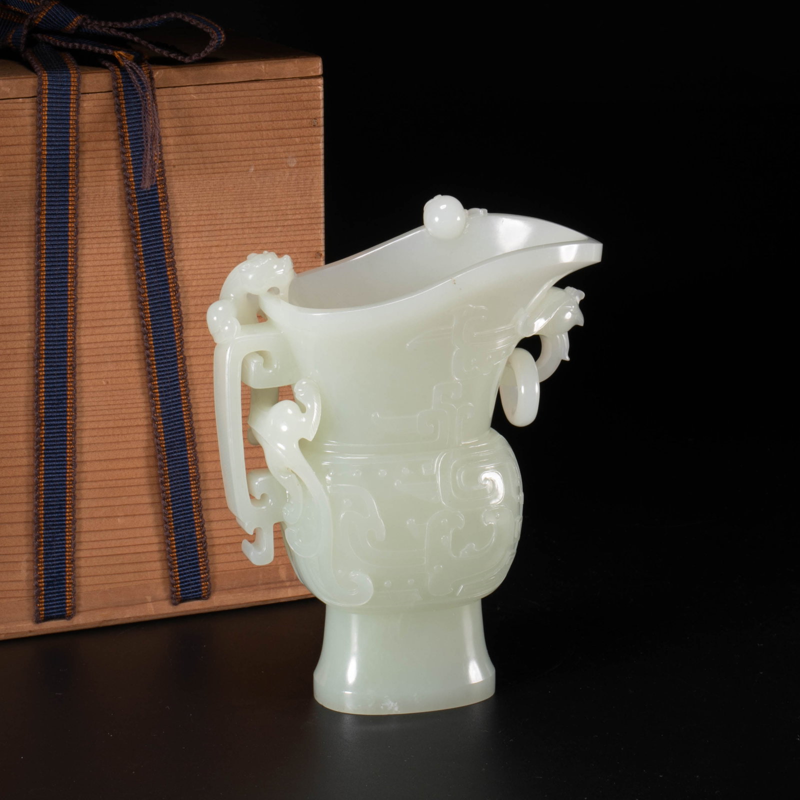 Qianlong Period of the Qing Dynasty, a Hotan white jade cup with dragon ears and phoenix heads: This is a Hetian white jade cup with dragon ears and phoenix heads carved from the Qianlong period of the Qing Dynasty. It is a masterpiece of antique jade carving for the court of the Qing