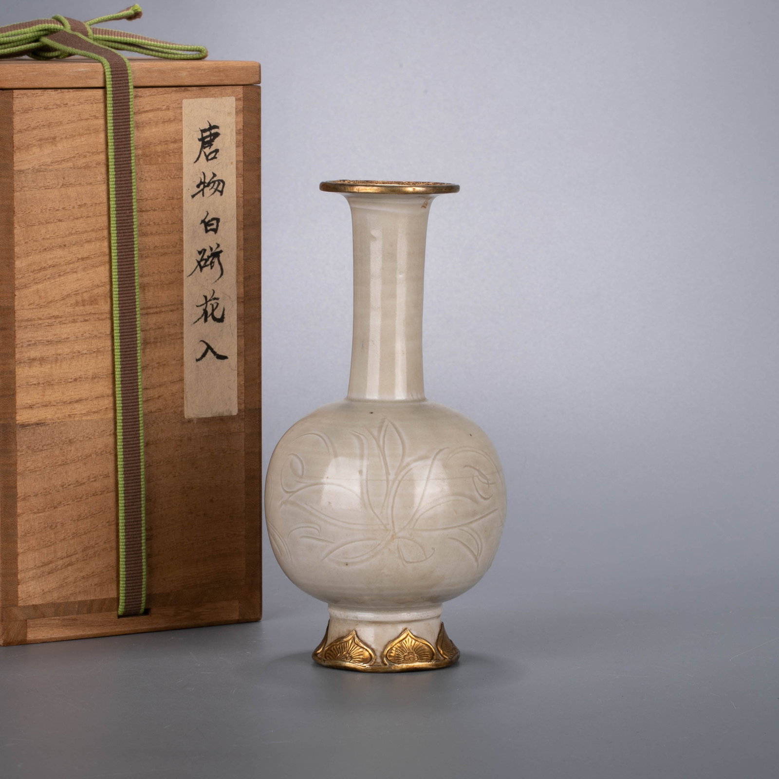 Song Dynasty Ding Kiln hanaire (Japanese flower vase): This is a Song Dynasty Ding kiln white glaze engraved with lotus pattern and covered with gold mouth long-neck vase (flower in). The shape of the vessel is an extravagant mouth, a slender straight
