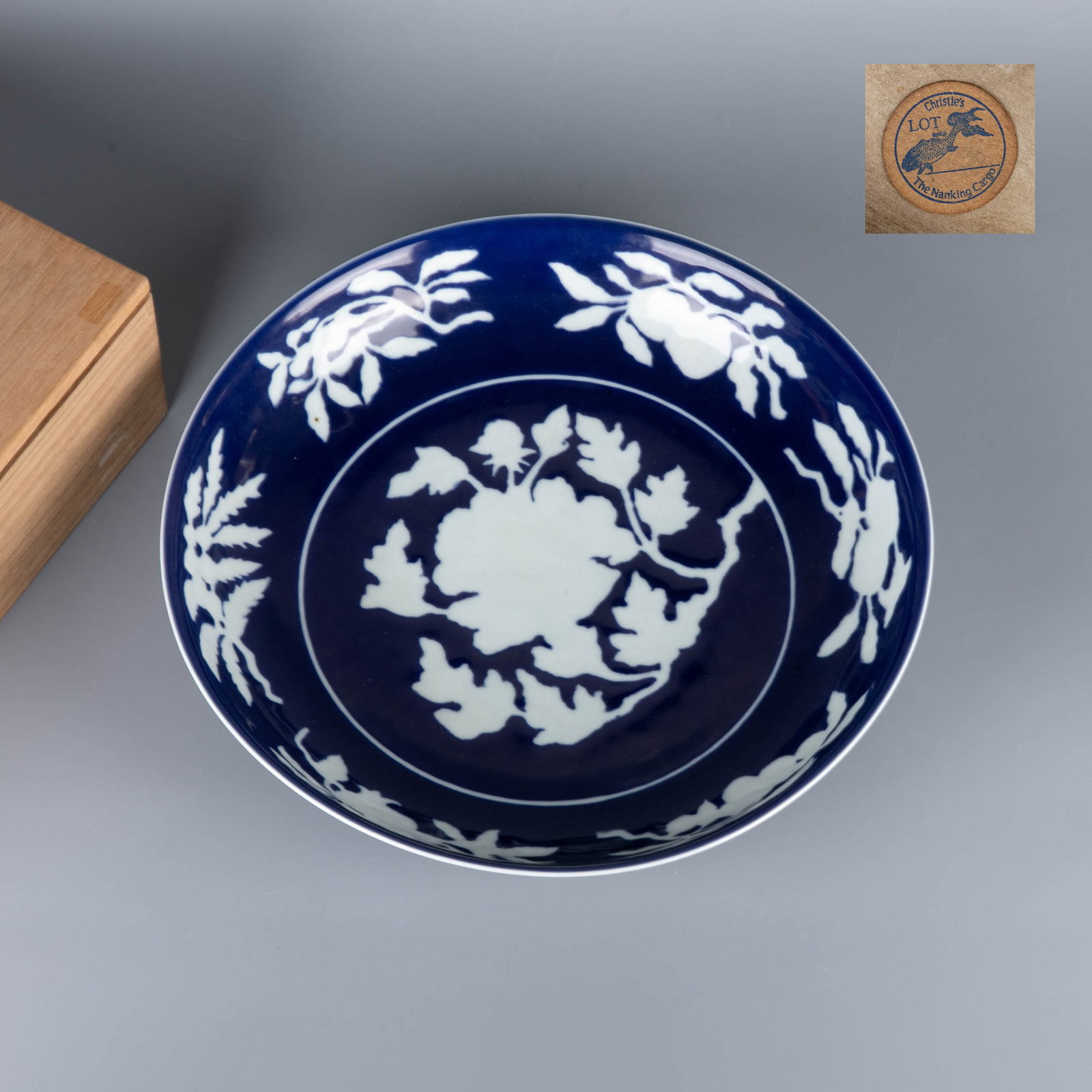 Ming Dynasty blue ground with white arabesque pattern plate: This is a plate with a bright blue ground and white intertwining branches and flowers (commonly known as a blue and white flower or reverse blue and white plate). The shape of the vessel is open,