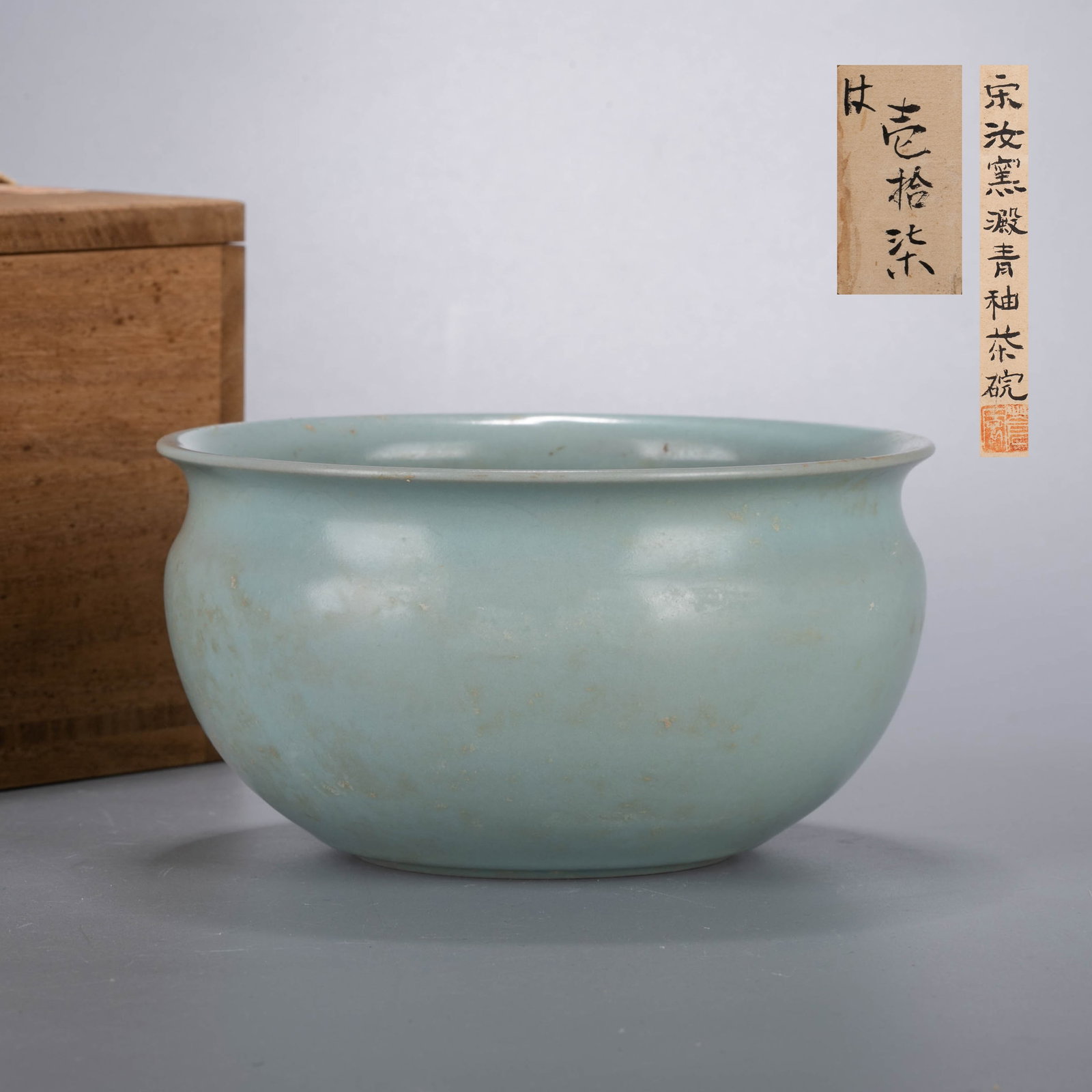 Song Dynasty Ru Kiln tea bowl: This elegant tea bowl is of deep, rounded form with a gently incurved rim and subtly tapering lower body, creating a harmonious silhouette of quiet refinement. The bowl is covered overall with a soft 
