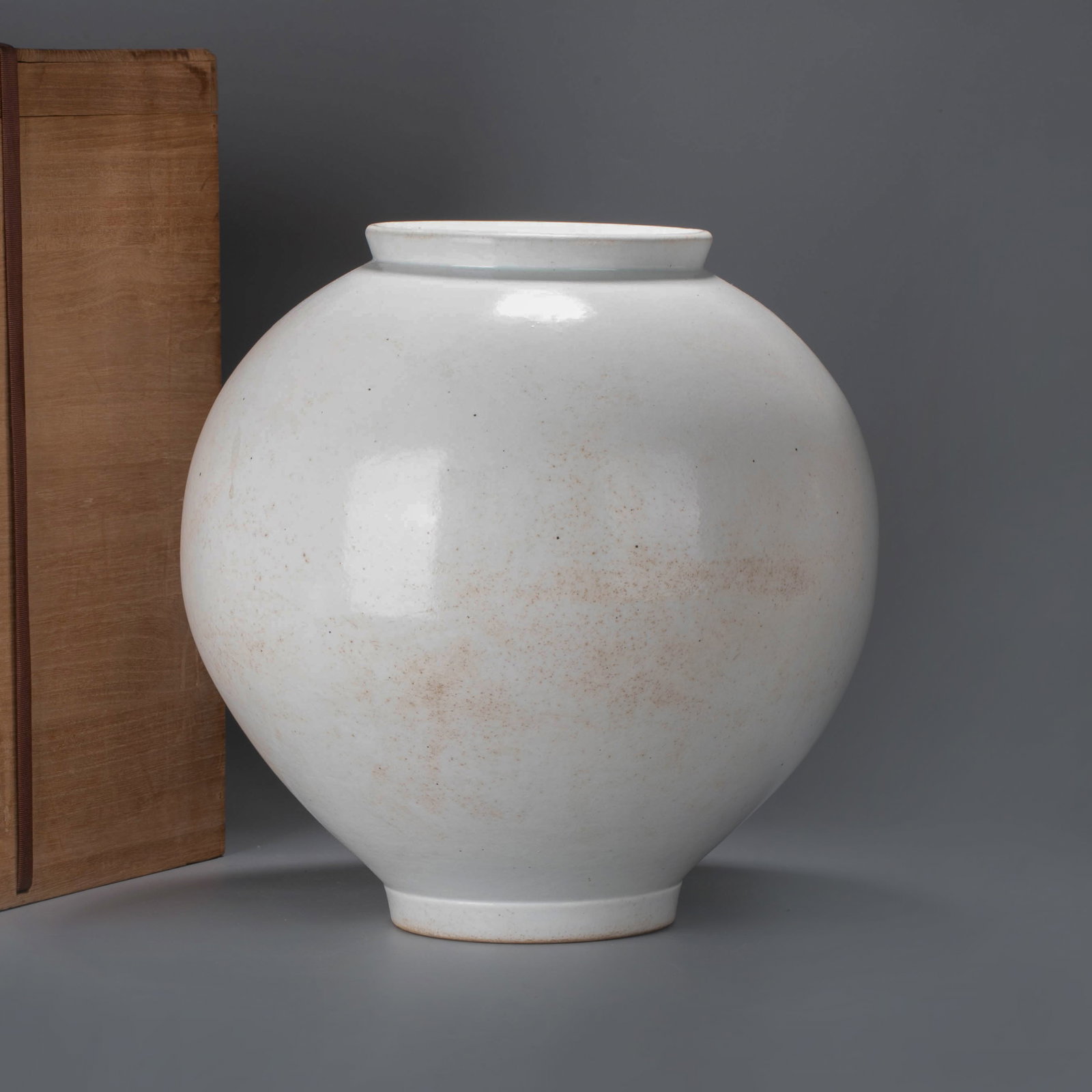 Pill vessel: This vessel is in the style of Joseon Dynasty white porcelain maru-tsubo, or rounded jar. It features a full, rounded body, a short neck, a slightly recessed mouth, and a small ring foot. The