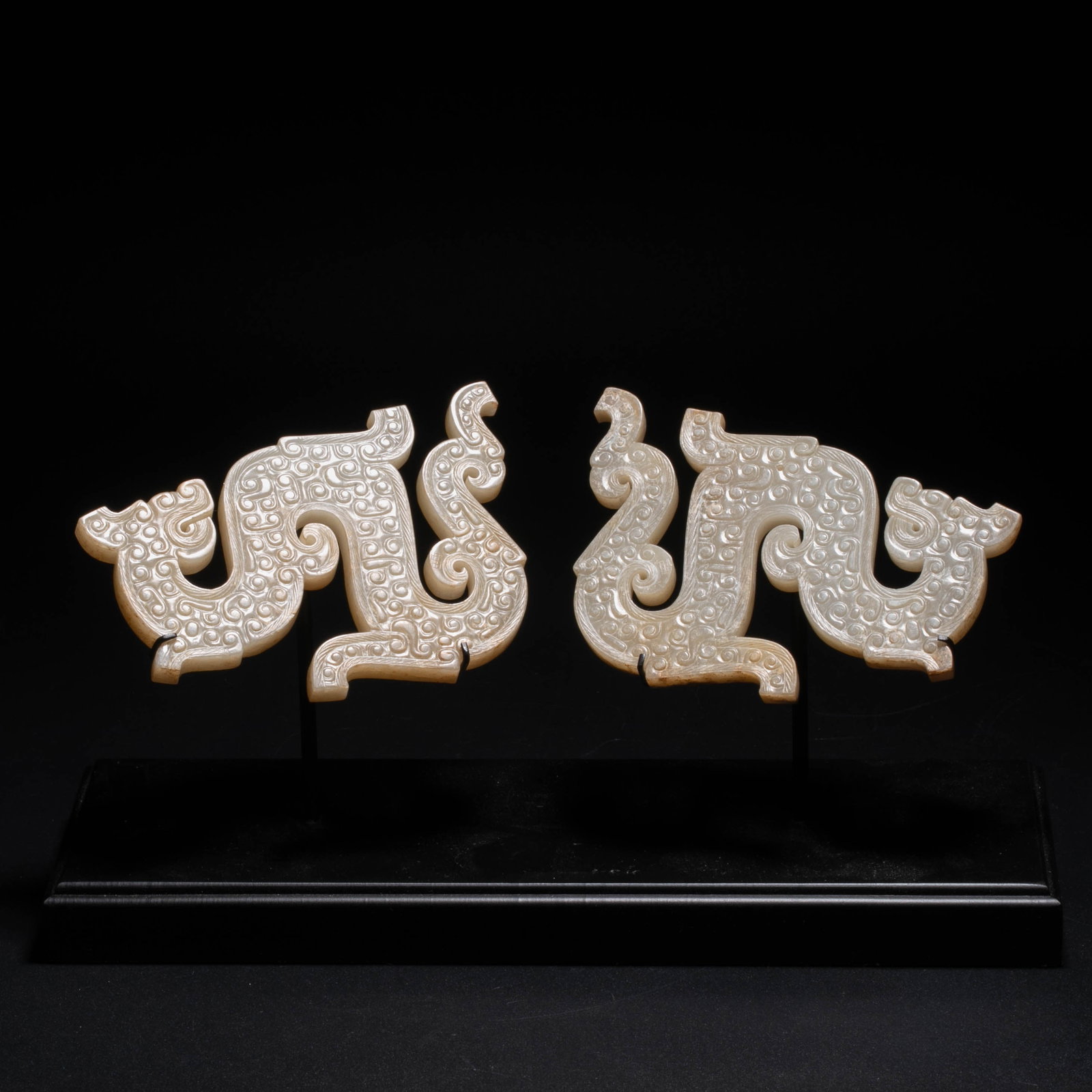 Warring States Period white jade Long Pei a pair: This pair of white jade dragon pendants is based on the typical paradigm of jade carvings during the Warring States Period, with an S-shaped dragon body in an unrolled shape, with the head and tail