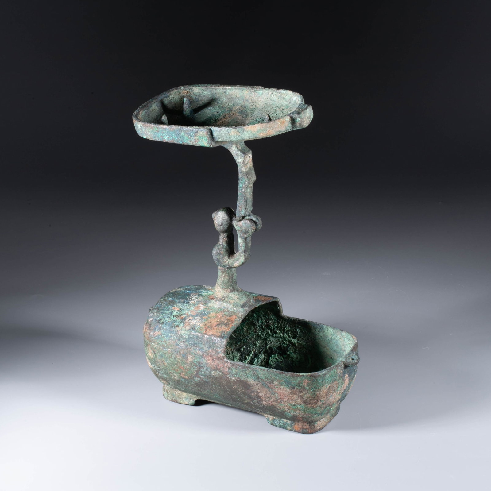 Chinese bronze lamp: This piece is a bronze running lamp from the Han dynasty (wild goose foot lamp / dish lamp type). The lamp dish has an open mouth, a shallow belly, a flat bottom, and a long handle at the bottom.