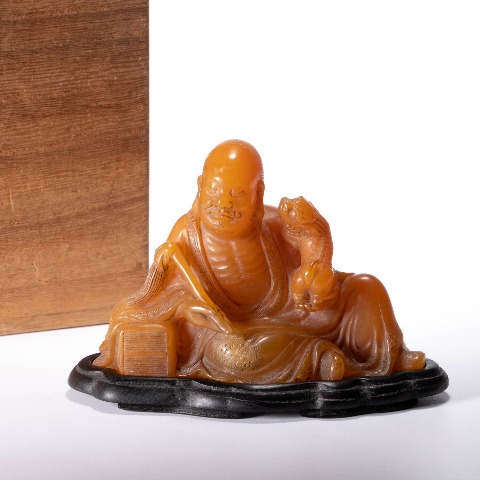 Qing Dynasty Jade Xuan Statue of Arhat with Yellow Fuhu in Shoushan Field: This image is a "Qing dynasty Jade Xuan" mark Shoushan Tianhuang Fuhu Arhat Statue, made of field yellow warm beeswax, shiny and restrained. The Arhat is reclining and sitting comfortably, with clear 