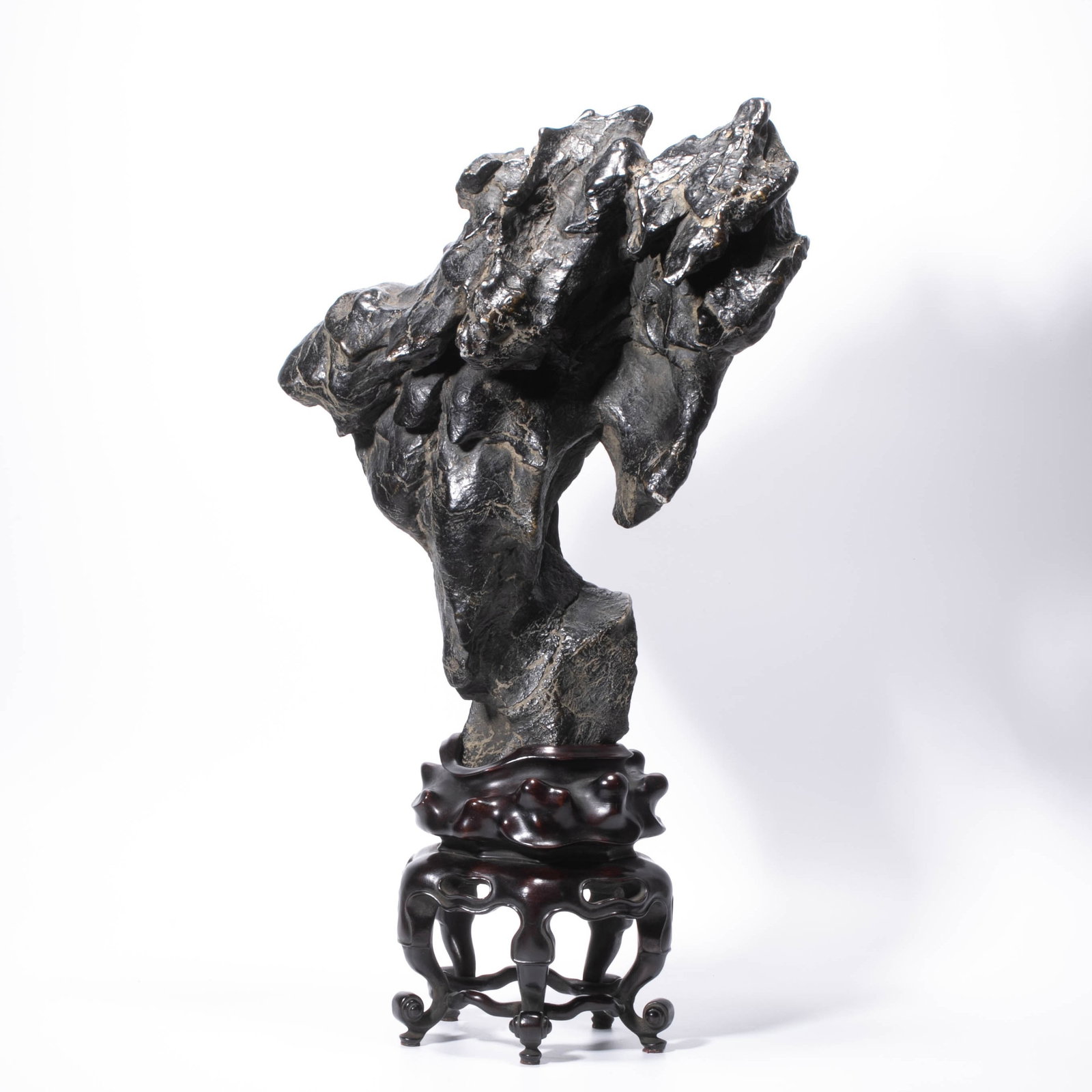 Lingbi stone standing peak scholar's object scholars?? viewing stone original base: This Lingbi stone is used as a scholar's object stone for the peak. The stone is dark and moist, with vertical and horizontal wrinkles on the surface. The ravines are stacked like cloud roots, with li