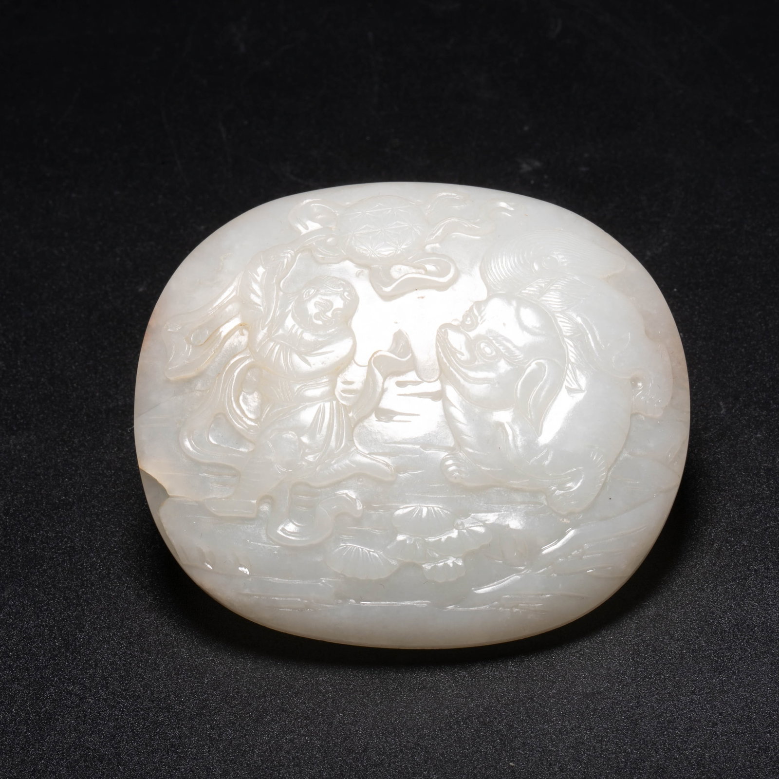 Qing Dynasty, Child Playing with a Auspicious Beast: This piece is from the Qing dynasty Hetian white jade "Barbarians Playing with Lions (Fans Xian Rui/Nongshi)" plaque. It is an oval-shaped thick piece. The jade is white and delicate, polished softly