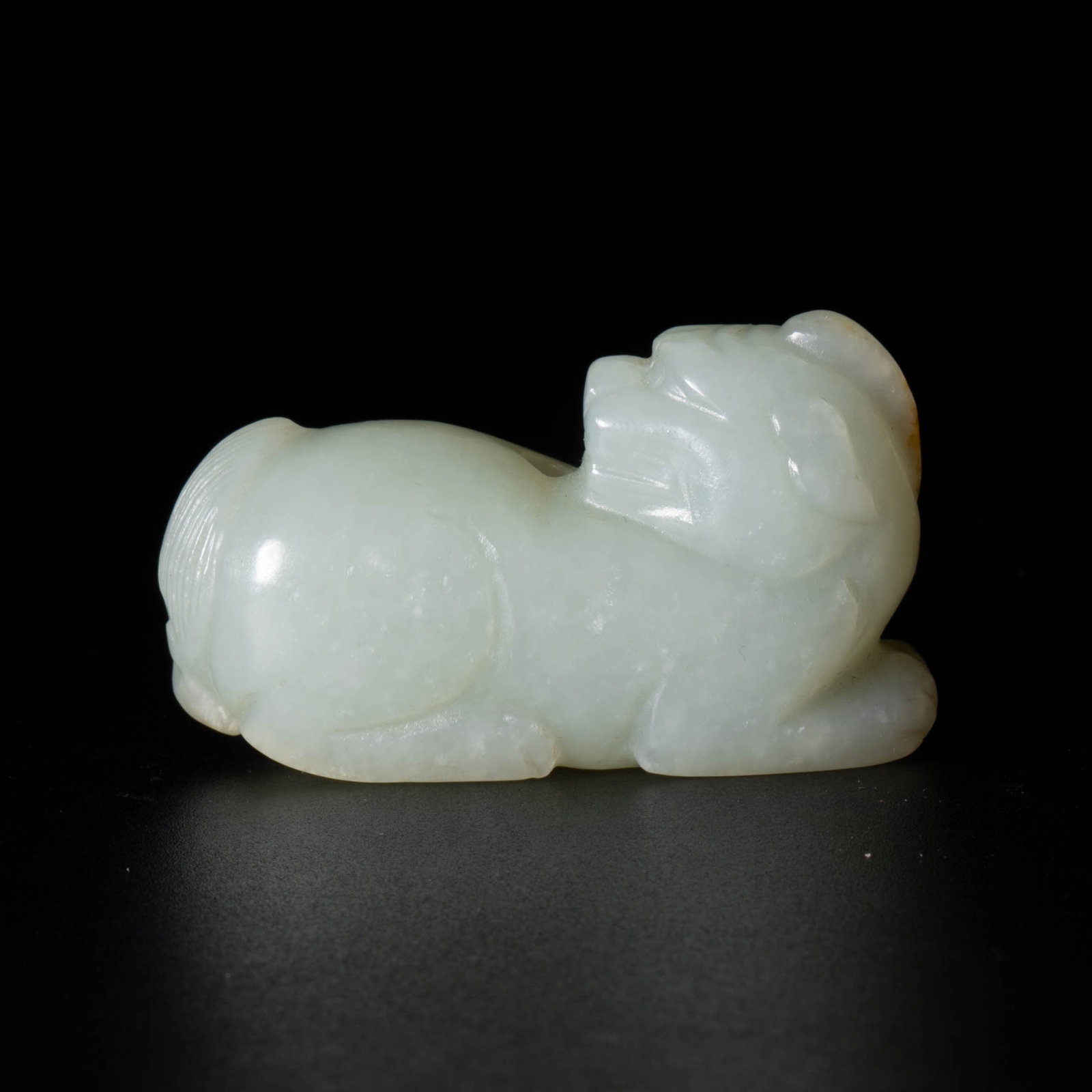 Yuan Dynasty russet-skinned auspicious beast: This Yuan dynasty style jade carving is a horizontal auspicious animal, with a bluish-white Hetian jade texture, warm and slightly translucent, with yellow/brown skin on the head and parts, forming a
