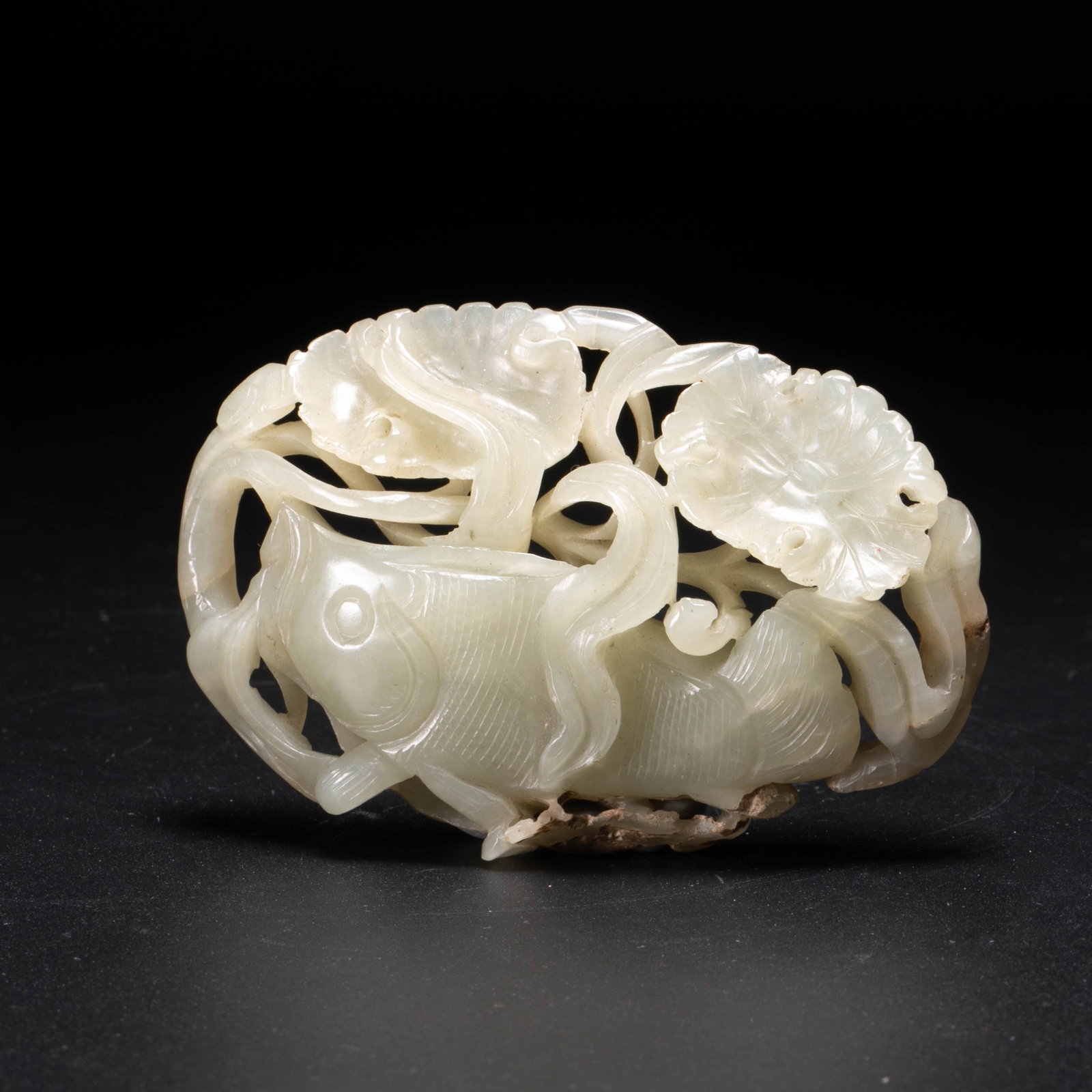 Yuan Dynasty mandarin fish playing among lotus: This Yuan dynasty style jade carving is a hollow ornament with the theme of "Mandarin fish playing with lotus/fish lotus". The jade is green-white and warm, with some yellowish-brown skin and soil