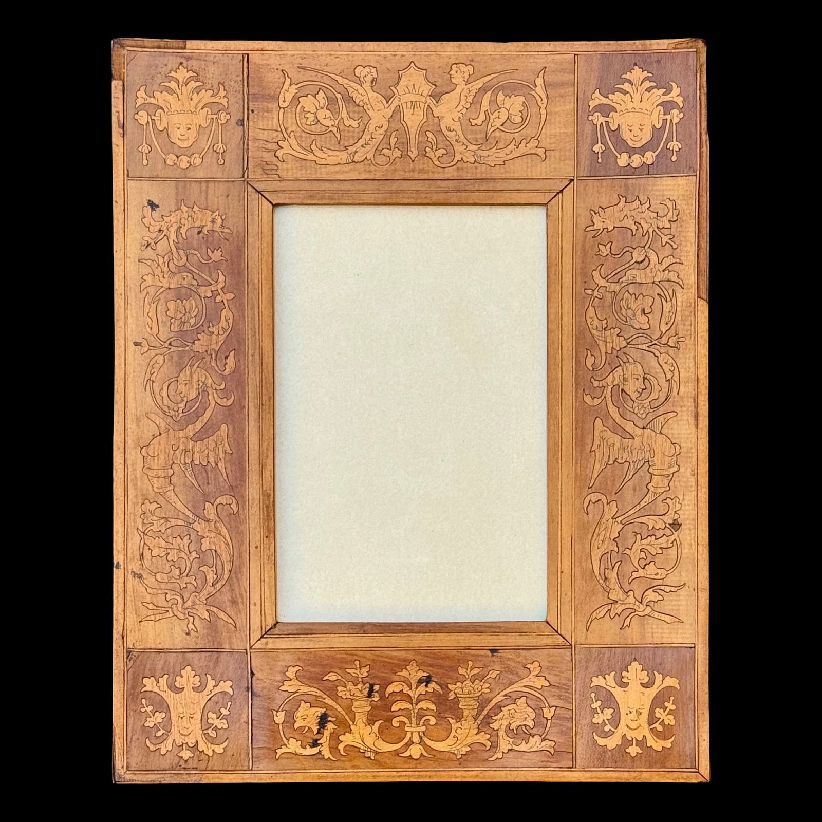 Italian Grotesque Inlaid Frame: Italian Grotesque Inlaid Frame Italian Renaissance Revival wooden frame with intricate marquetry inlay and classical foliate scrollwork. Featuring grotesque masks, floral motifs, and crest elements;