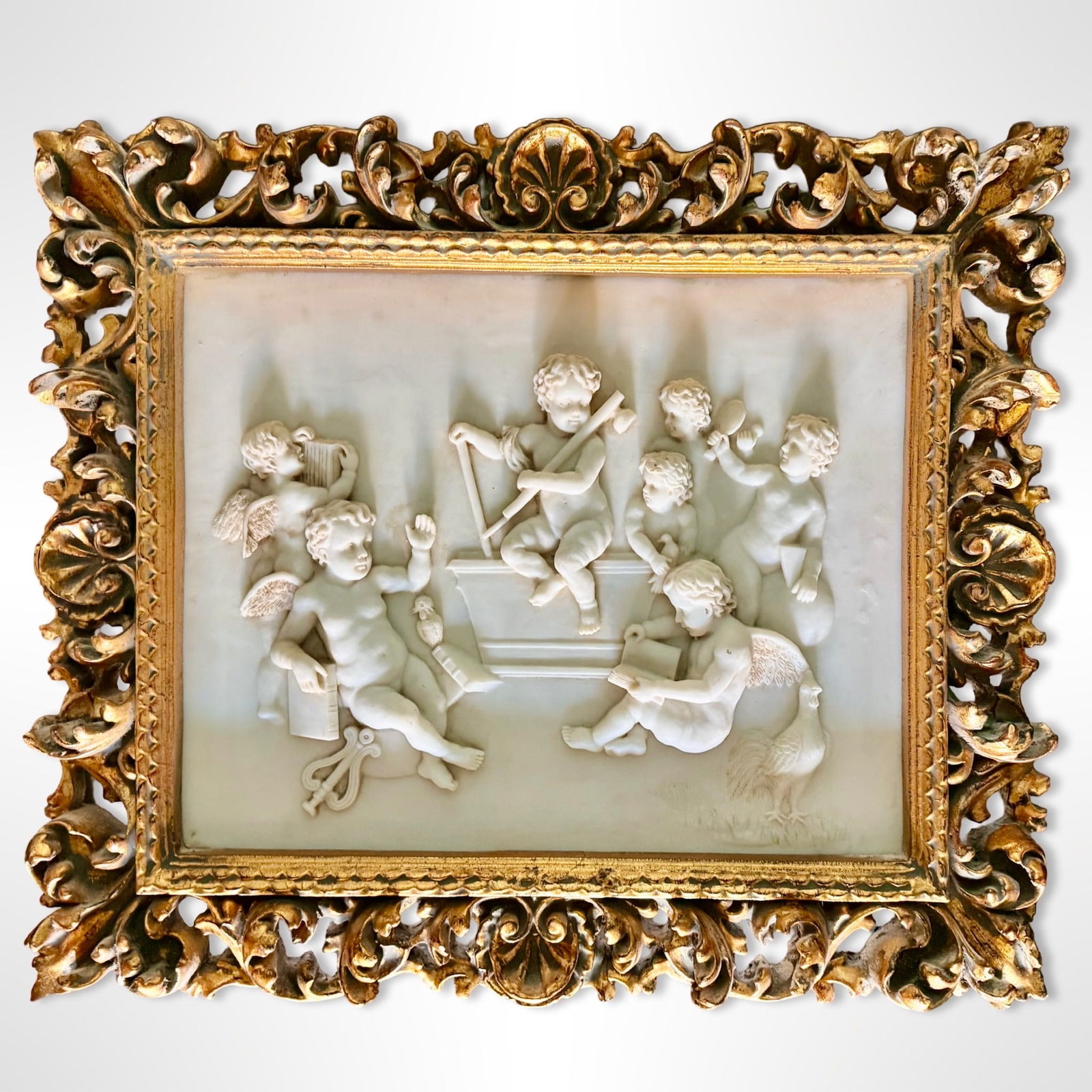 Italian Marble Cherub Wall Plaque: Italian Marble Cherub Wall Plaque Italian marble cherub wall plaque of musical putti, set in a carved giltwood frame. Dimensions:
