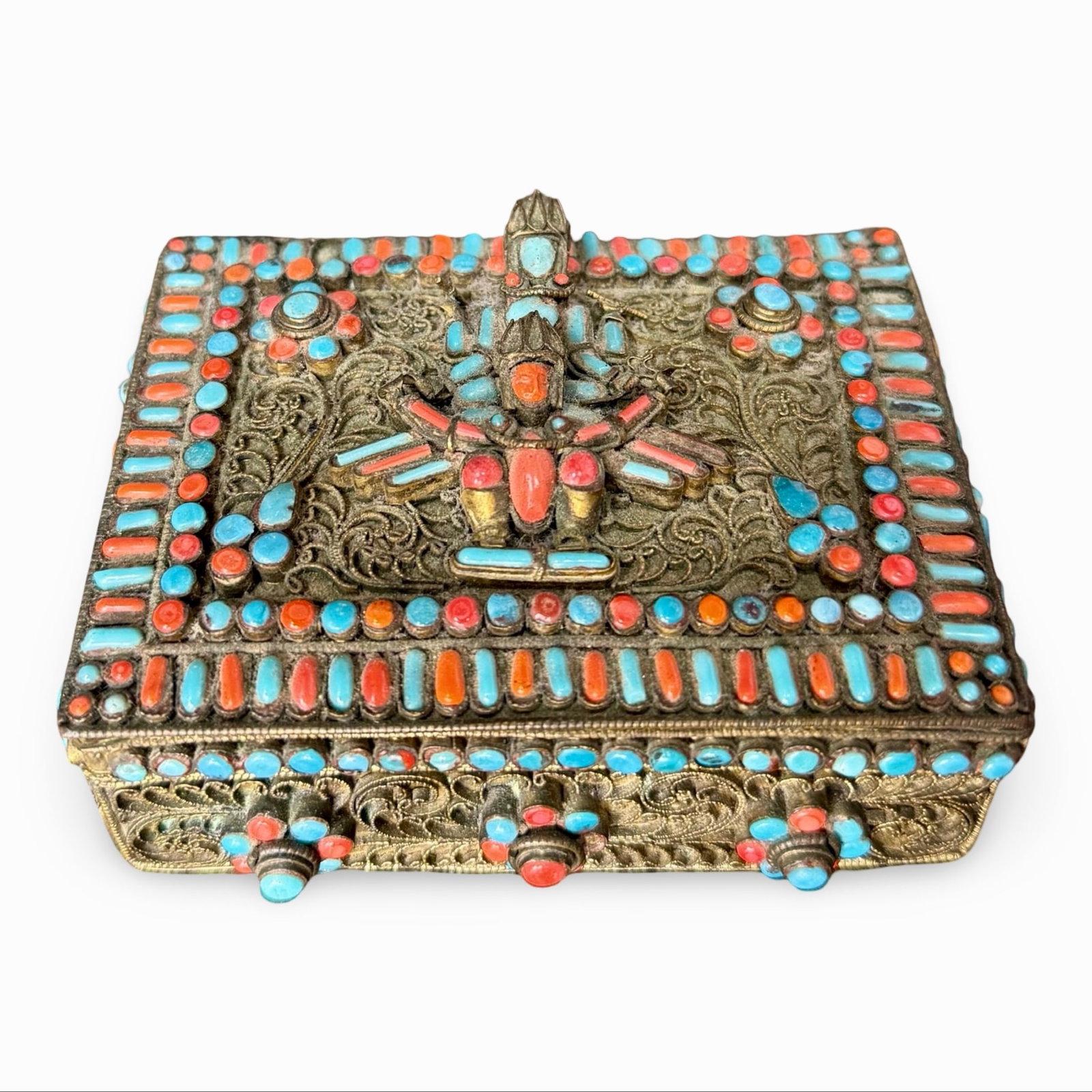 Tibetan Filigree Inlaid Jewelry Box: Brass filigree jewelry box with diety and coral and turquoise inlay. Likely Nepalese or Tibetan. Approx. Dimensions: