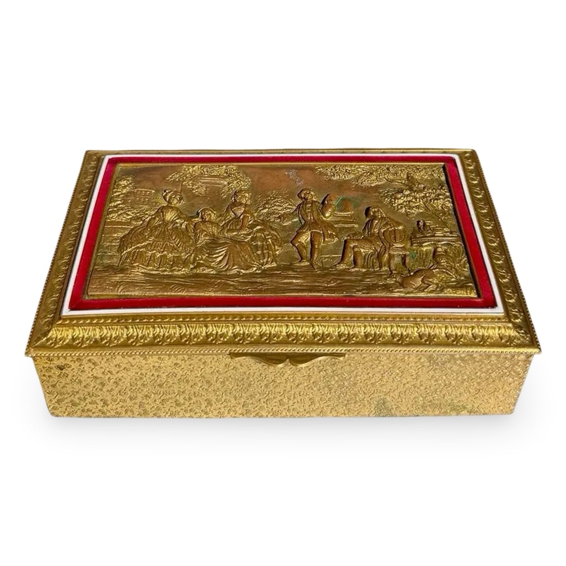 Ovington French Bronze Repousse Box: Antique gilt bronze casket box by Ovington New York with repoussé pastoral scene, red enamel border, and wood lined interior. French made. Stamped on interior of the lid. Dimensions: 1.5H x 5.5W x 3.