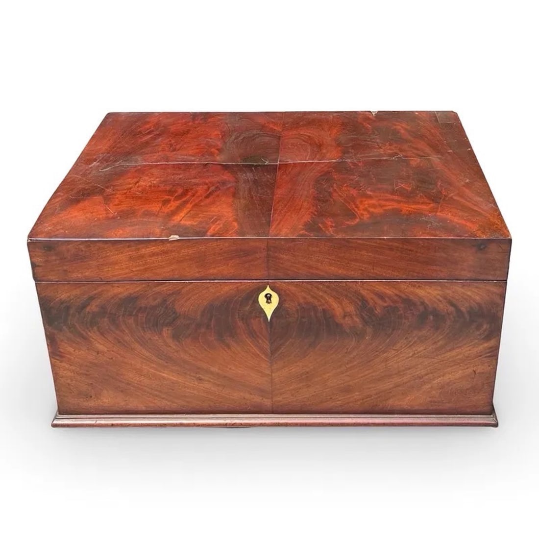 Antique Federal Flame Mahogany Box: Antique flame mahogany casket box tea caddy with inlaud escutcheon, side handles, and engraved initials IVL on inside of lid. Approx. Dimensions: 10.5H x 20W 12.5D inches