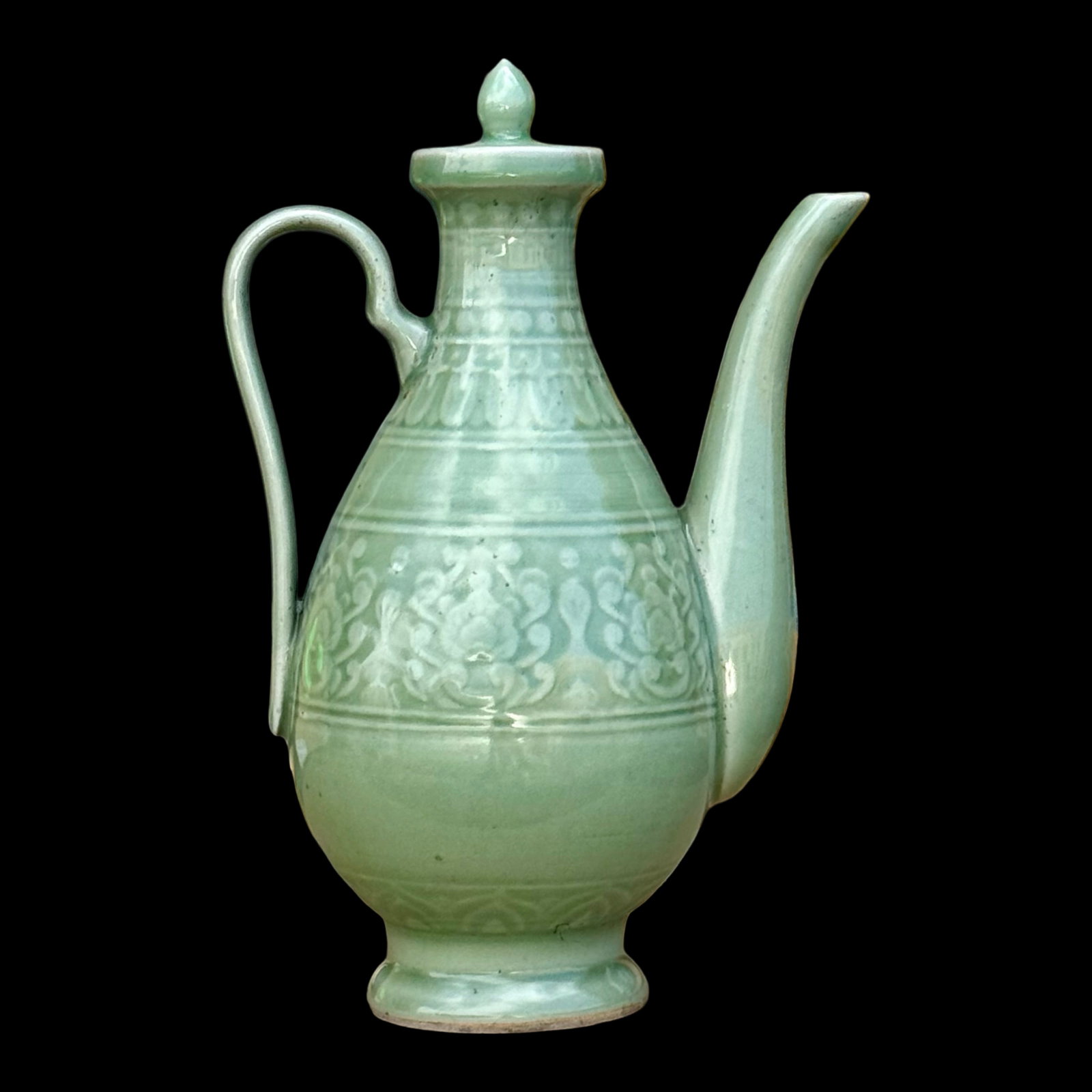 Chinese Celadon Ewer Teapot: Chinese Longquan-style celadon ceramic ewer teapot with a fitted lid. Decorated with molded scrolling floral motifs and horizontal ring accents, finished in a jade-green celadon glaze.