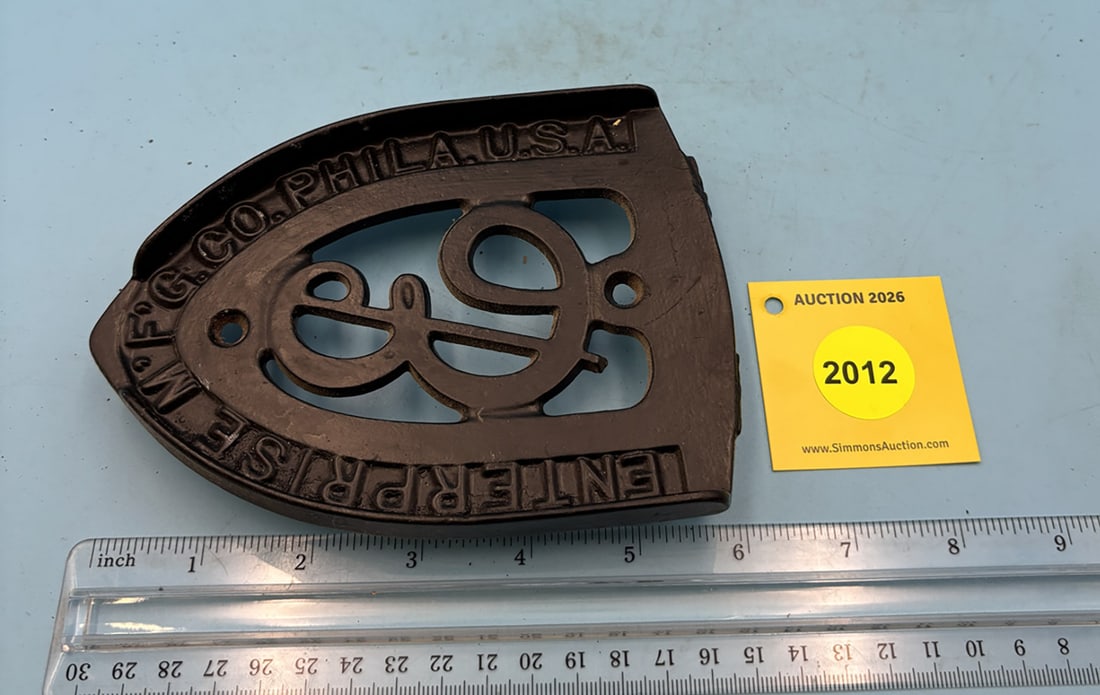 Enterprise E 6'' x 4 3/8'' w/ three feet trivet. Reads "Enterprise M'F'G. Co. PHILA USA". Two rough (1 of 2)