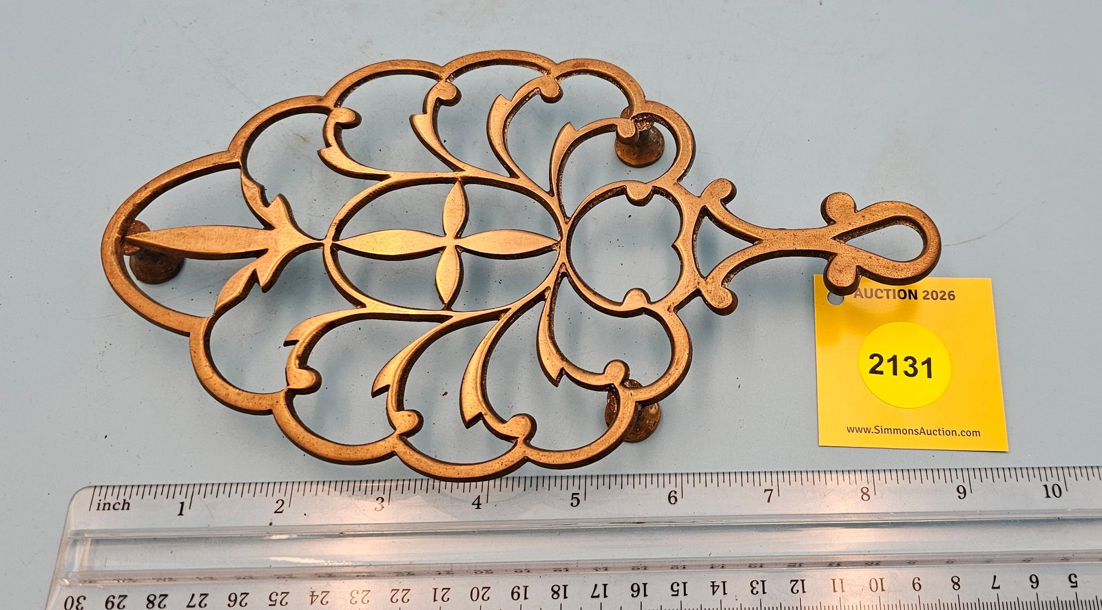 Unsigned India brass open scroll pattern 9'' x 5'' w/ three feet trivet.: Unsigned India brass open scroll pattern 9'' x 5'' w/ three feet trivet.