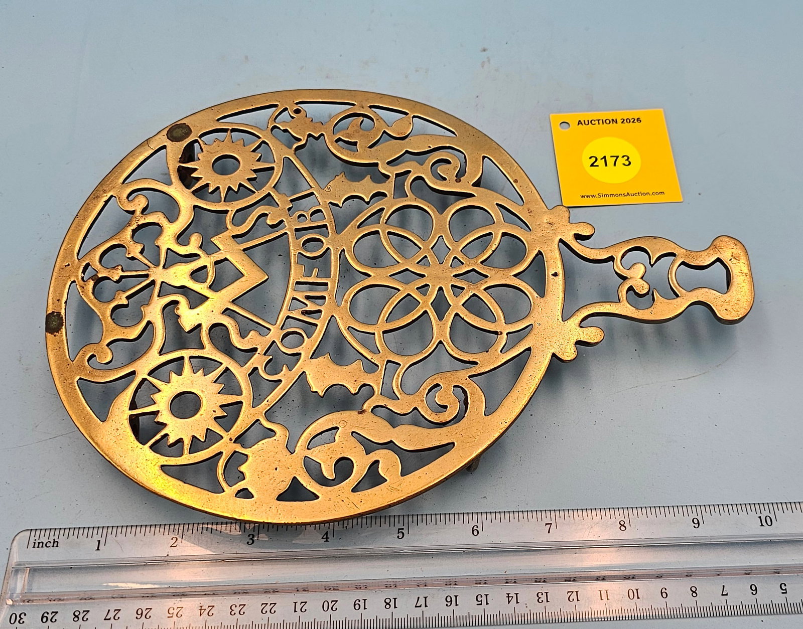 Round brass trivet, "Comfort", 10 1/4 x 7 1/2 x 7/8": Round brass trivet, "Comfort", 10 1/4 x 7 1/2 x 7/8"