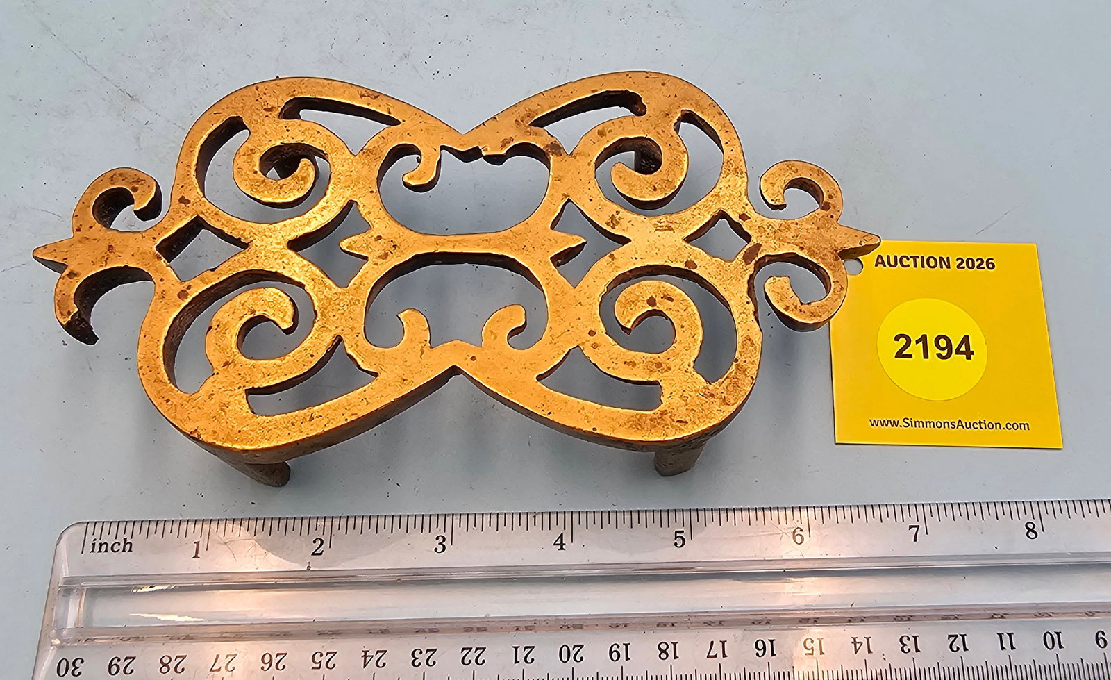 Brass trivet, no markings, one piece of handle is broke off and part of inside design, 6 7/8 x 3 ...: Brass trivet, no markings, one piece of handle is broke off and part of inside design, 6 7/8 x 3 1/2 x 1 3/8"