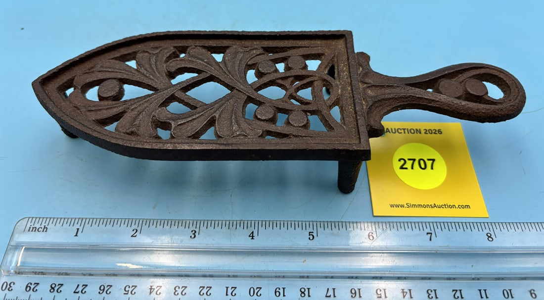 unmarked decorative narrow trivet w/ handle and three feet: unmarked decorative narrow trivet w/ handle and three feet
