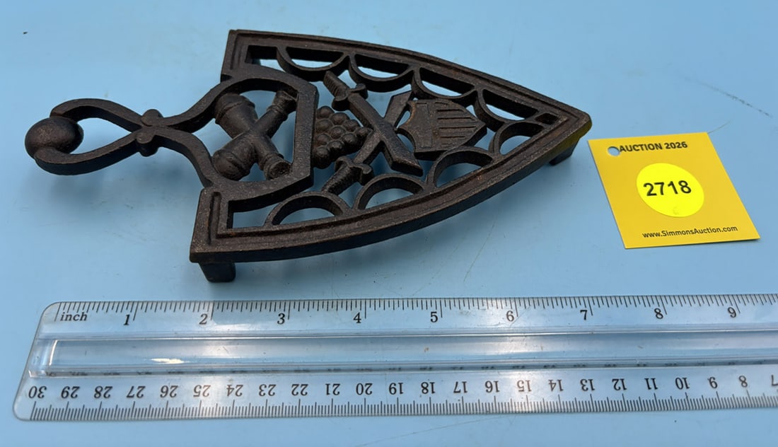 Military (cannon balls, sabre, and shield) trivet w/ handle and three feet (1 of 2)