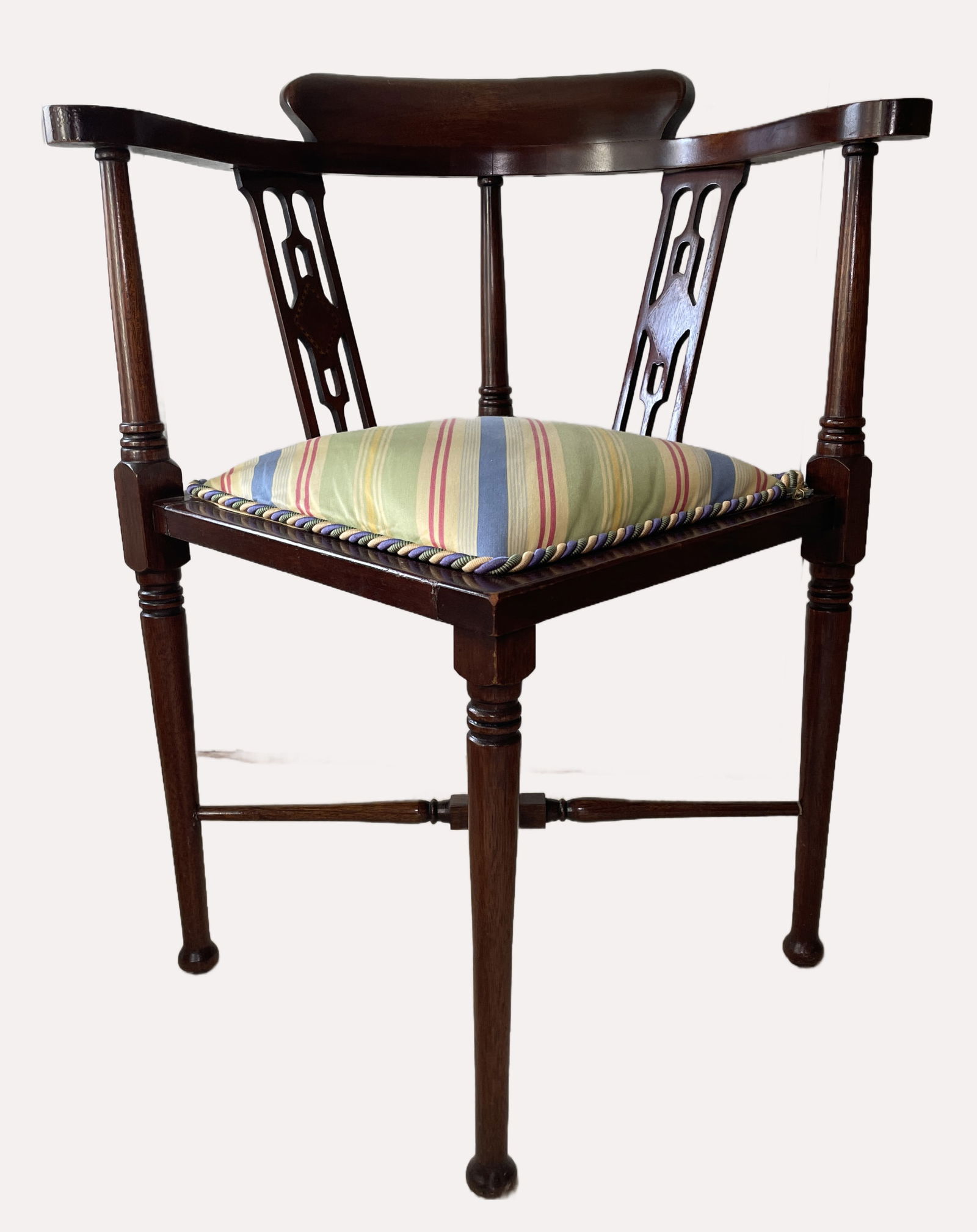 Antique Edwardian corner armchair: Antique Edwardian corner armchair constructed from mahogany wood. Features a distinctive corner shape, curved backrest, and often includes pierced fretwork splats. From Brandt for Heritage