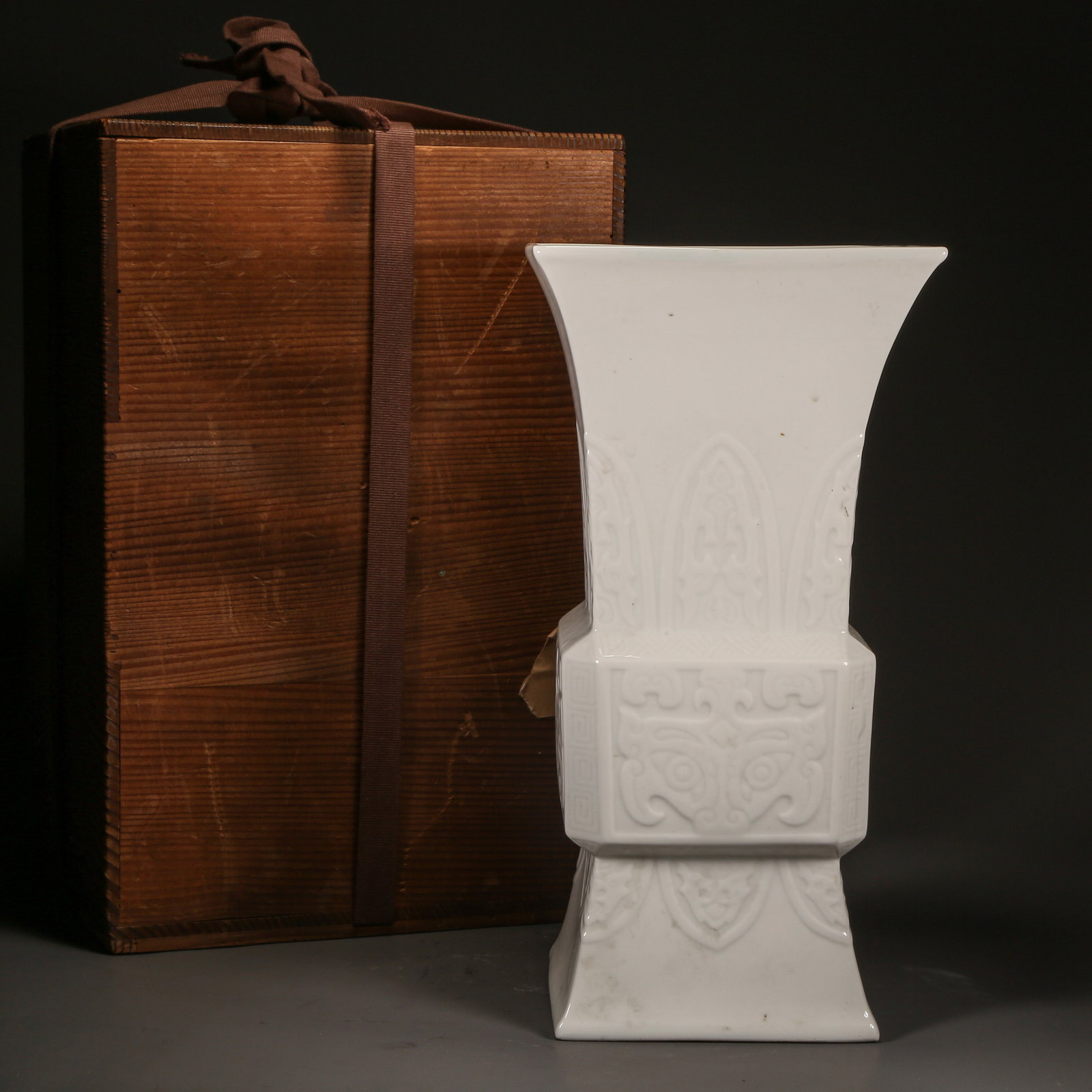 A QING DYNASTY WHITE-GLAZED SQUARE FLOWER GU WITH RAISED BEAST-FACE PATTERN: Qing Dynasty White-Glazed Square Flower Gu with Raised Beast-Face Pattern